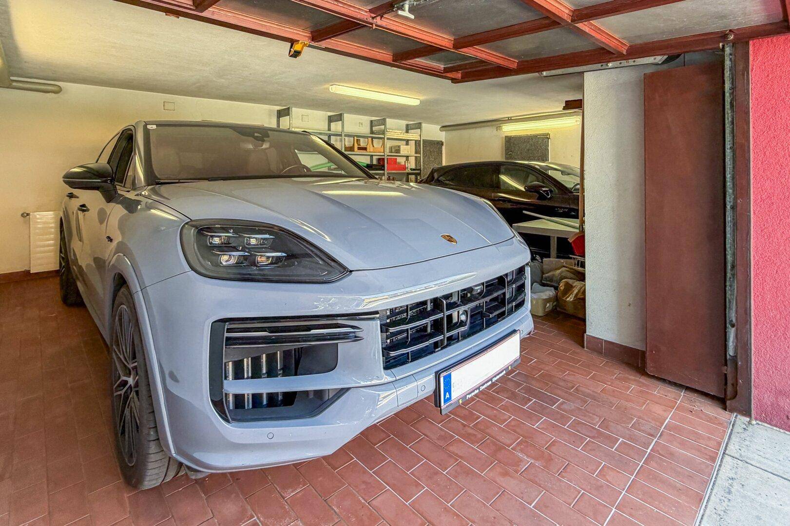 Geräumige Garage mit Fliesenboden, Platz für zwei Fahrzeuge und Stauraum.