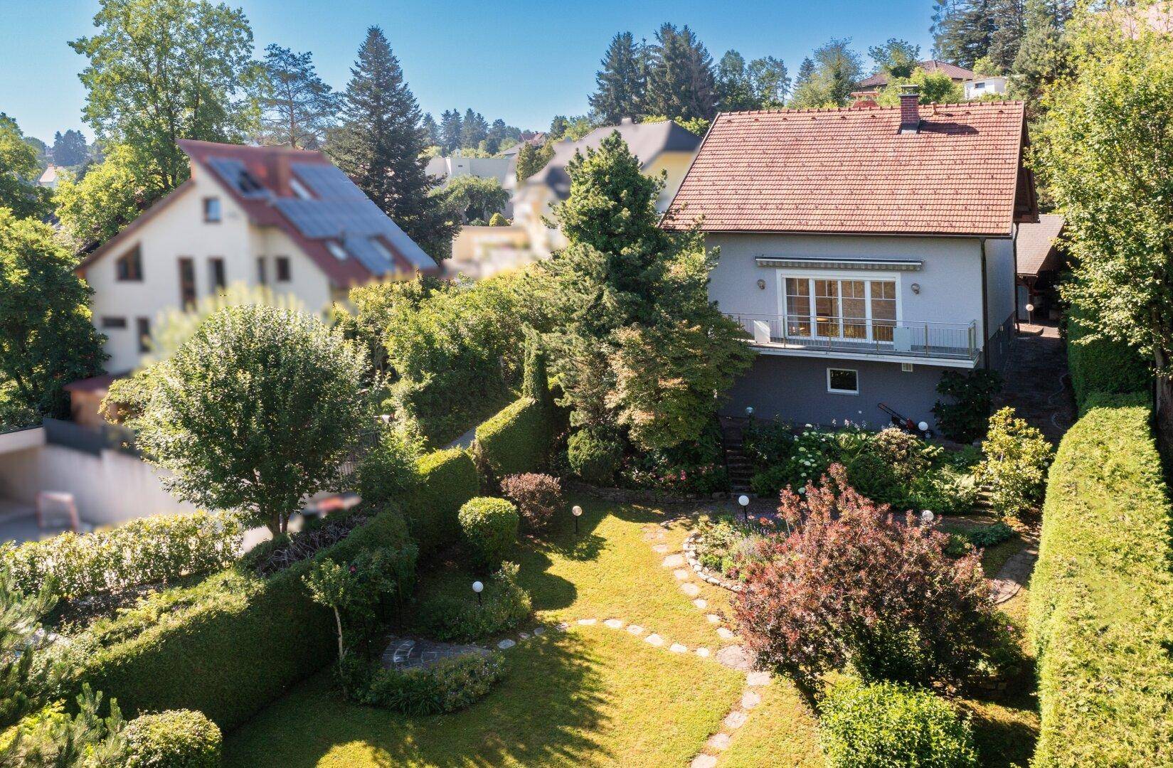 Luftaufnahme des Hauses mit großem, gepflegtem Garten und umliegender grüner Landschaft.