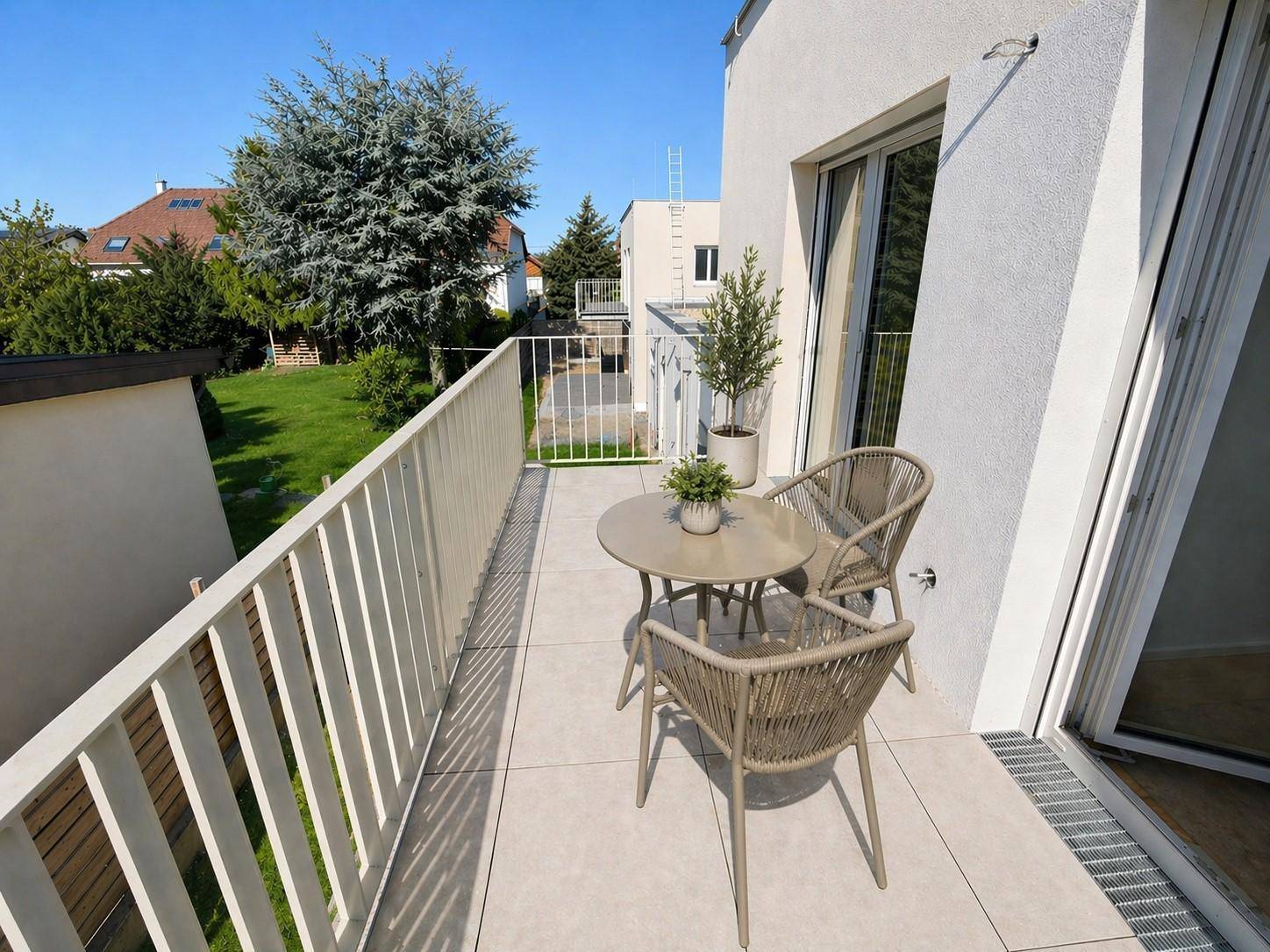 Gemütlicher Balkon mit Sitzgelegenheiten und Blick auf die grüne Umgebung.