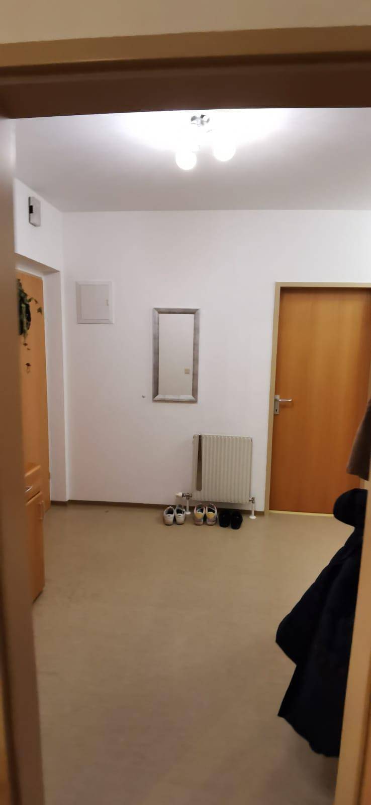 Heller Flur mit Garderobe, Spiegel und Zugang zu verschiedenen Zimmern der Wohnung.