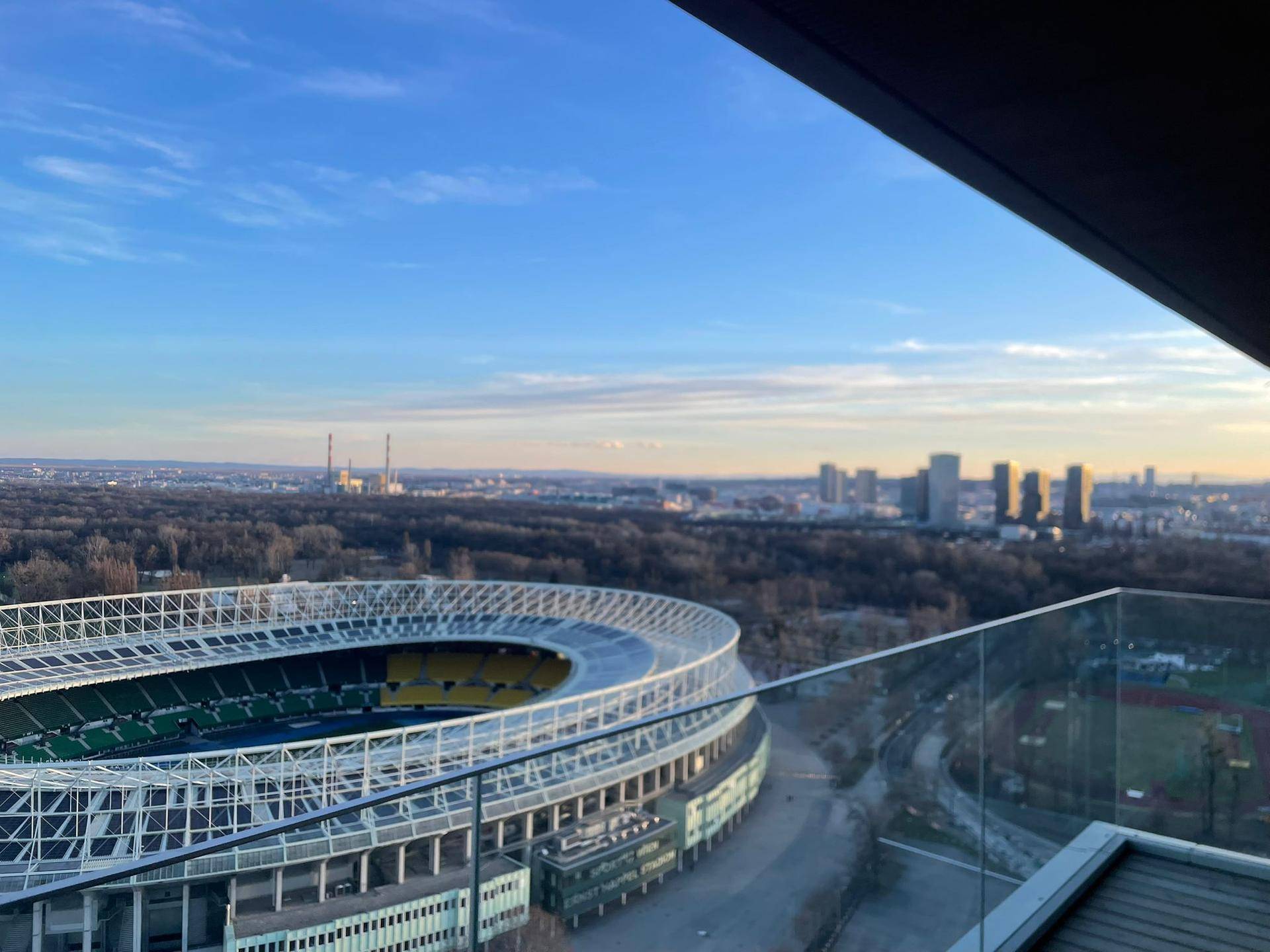 Weitläufiger Ausblick vom Balkon auf das Stadion und die Skyline der Stadt.