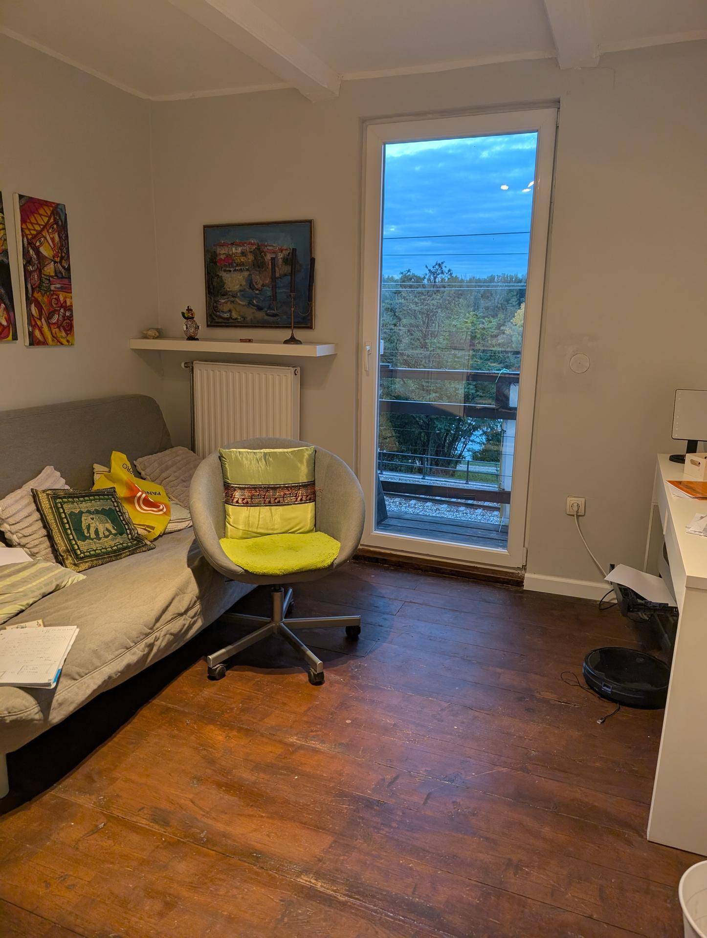 Wohnzimmer mit Sofa, Sessel und Zugang zu einem französischen Balkon mit Aussicht.