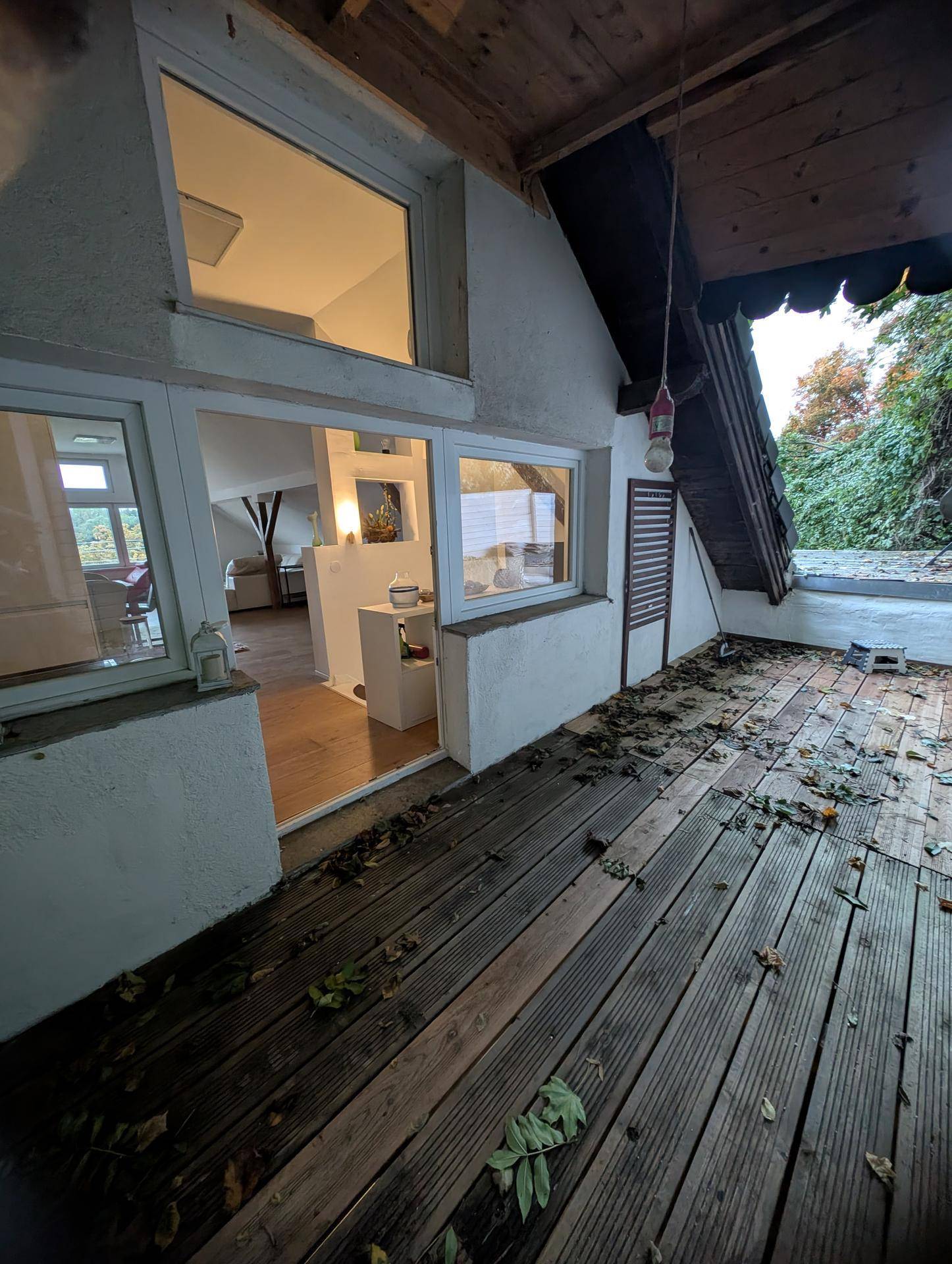 Hölzerner Balkon mit Blick auf die grüne Umgebung und Zugang zum Innenbereich des Hauses.