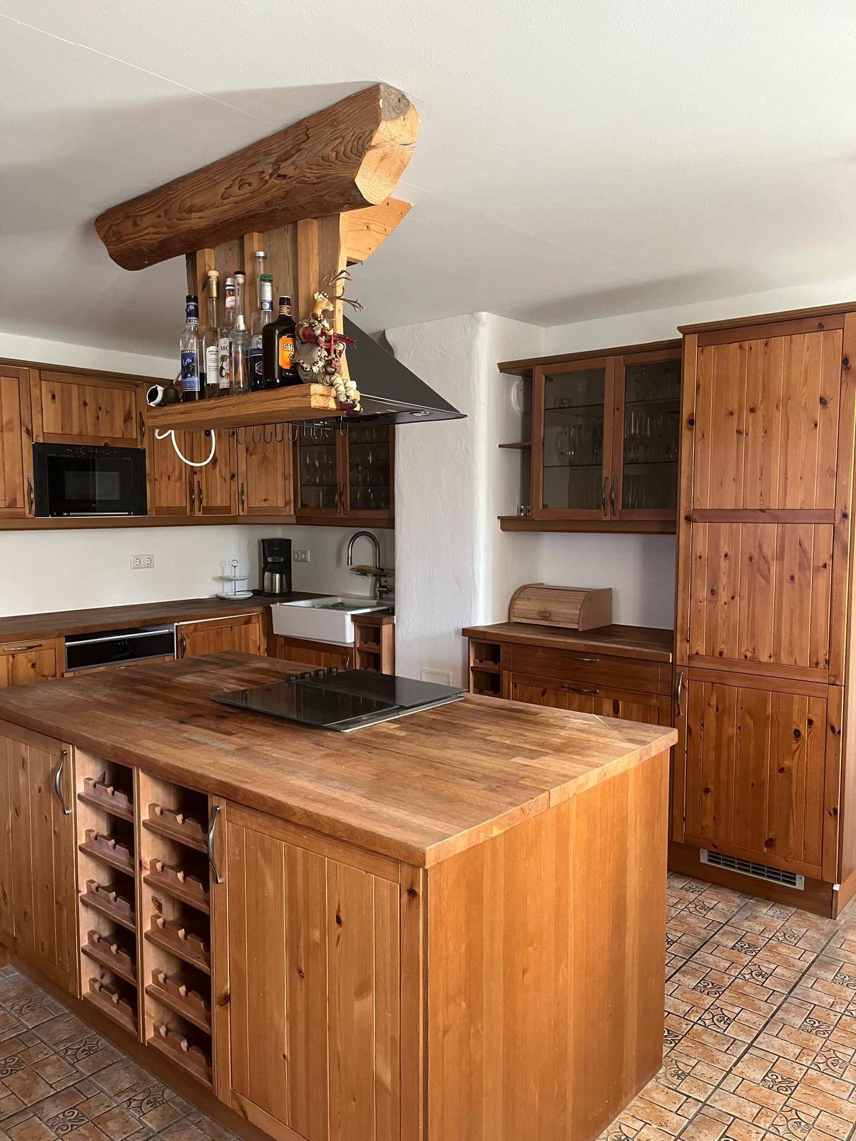 Traditionelle Holzküche mit Kücheninsel, Einbaugeräten und rustikalem Charme für Kochliebhaber.