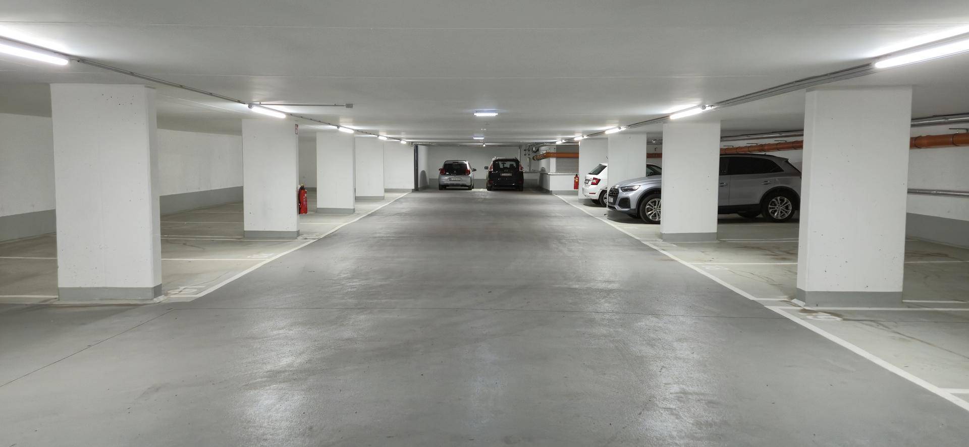 Geräumige Tiefgarage mit vielen freien Stellplätzen und heller, funktionaler Beleuchtung.