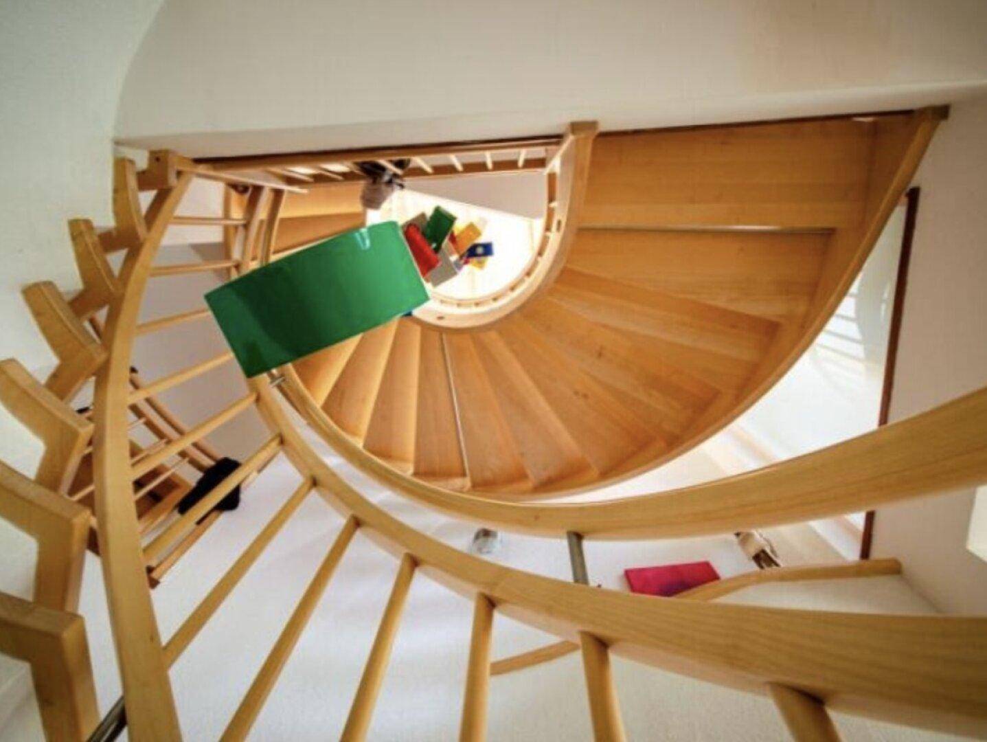 Helle Holzwendeltreppe, die die verschiedenen Ebenen des Hauses miteinander verbindet.