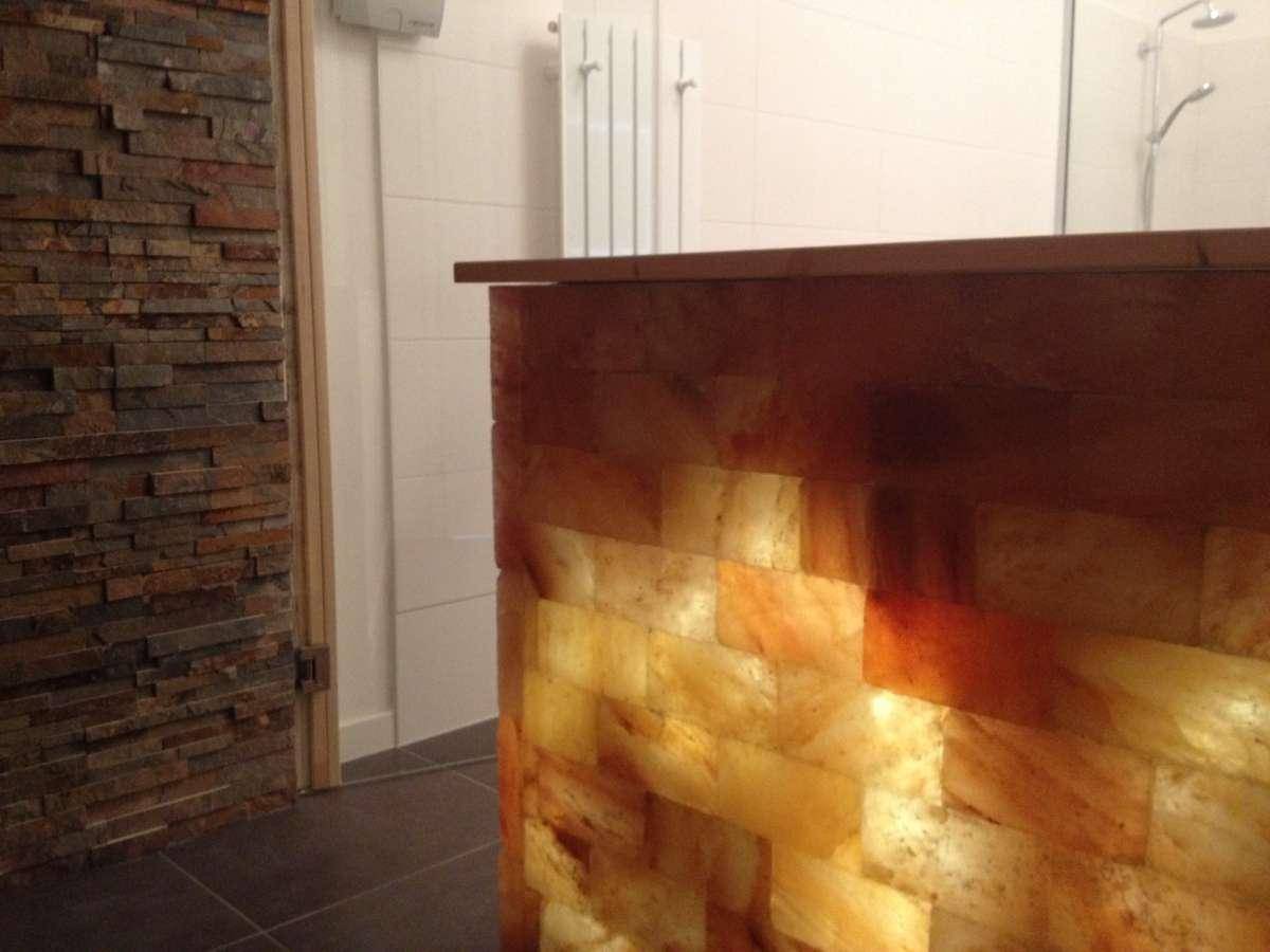 Beleuchtete Salzsteinwand als besonderes Merkmal im Wellnessbereich.