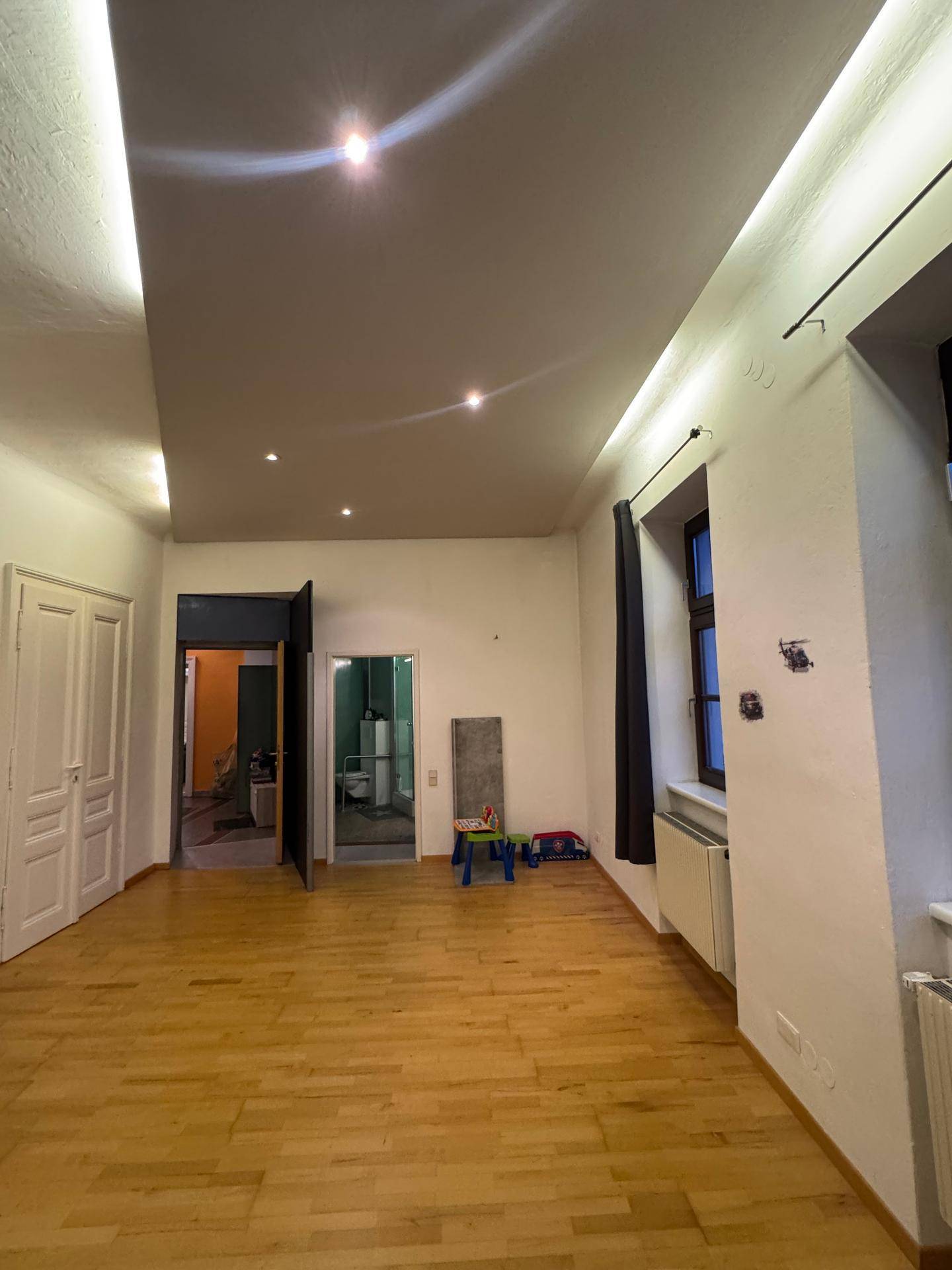 Geräumiges Kinderzimmer mit Parkettboden und Zugang zu anderen Räumen.
