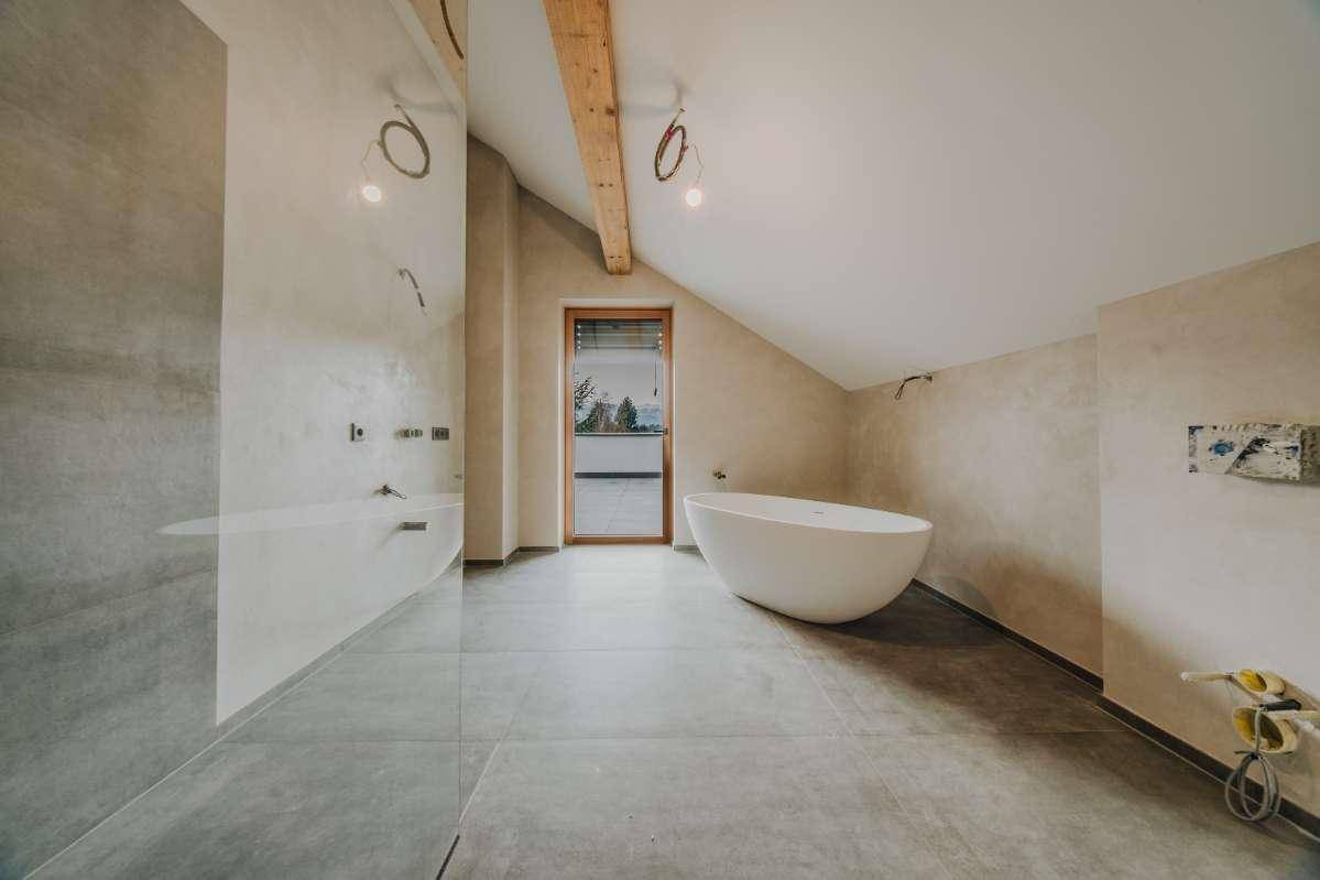 Geräumiges Badezimmer im Bau mit freistehender Badewanne und Zugang zur Terrasse.