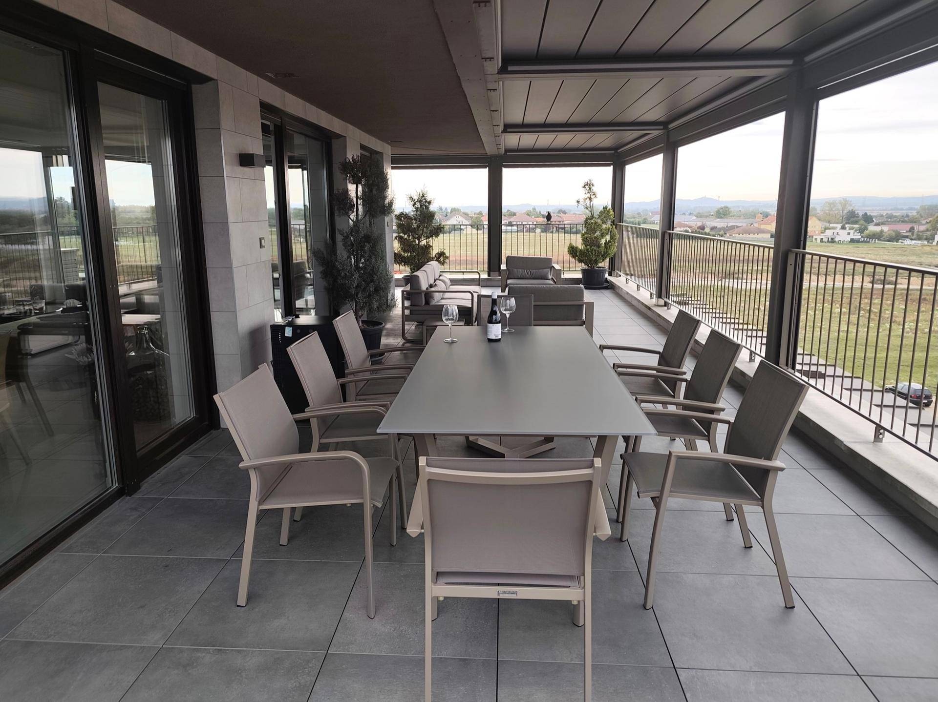 Große überdachte Terrasse mit Esstisch und Lounge-Bereich, ideal für Unterhaltung.
