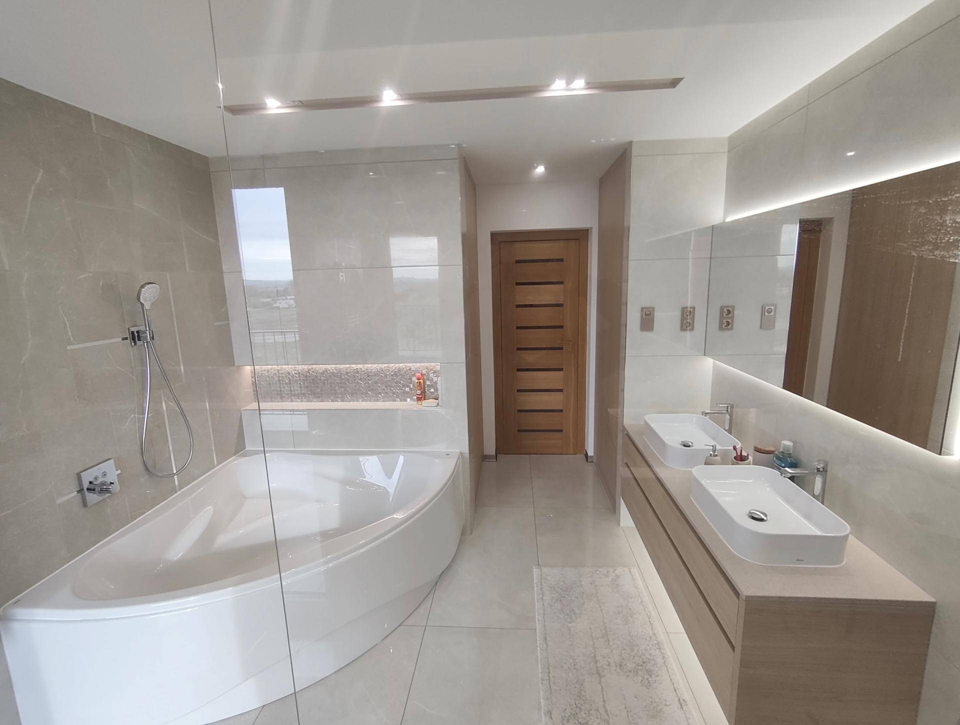 Elegantes Badezimmer mit Doppelwaschbecken, Badewanne und Duschbereich.