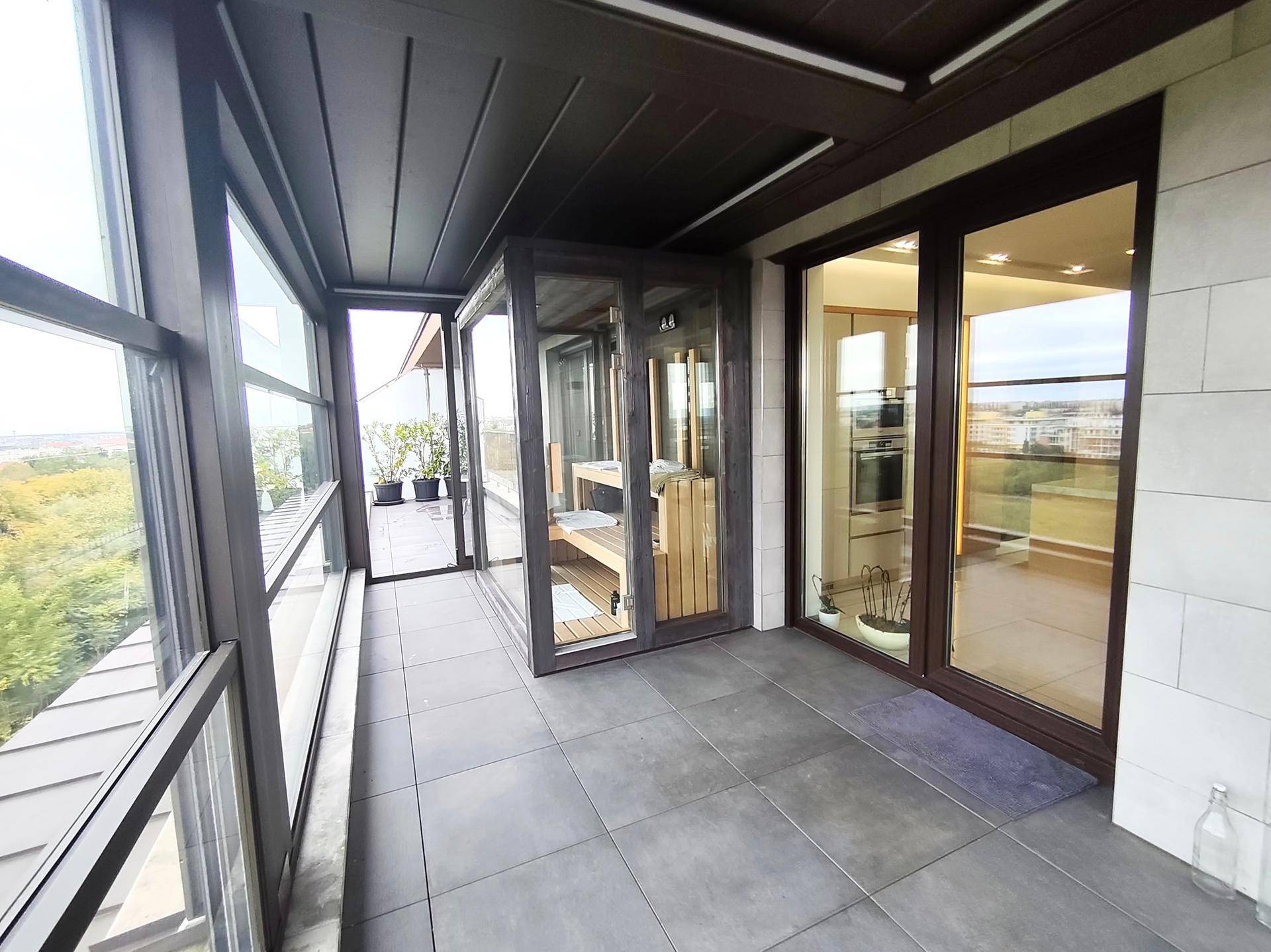 Überdachter Balkon mit integrierter Sauna und weitem Ausblick.
