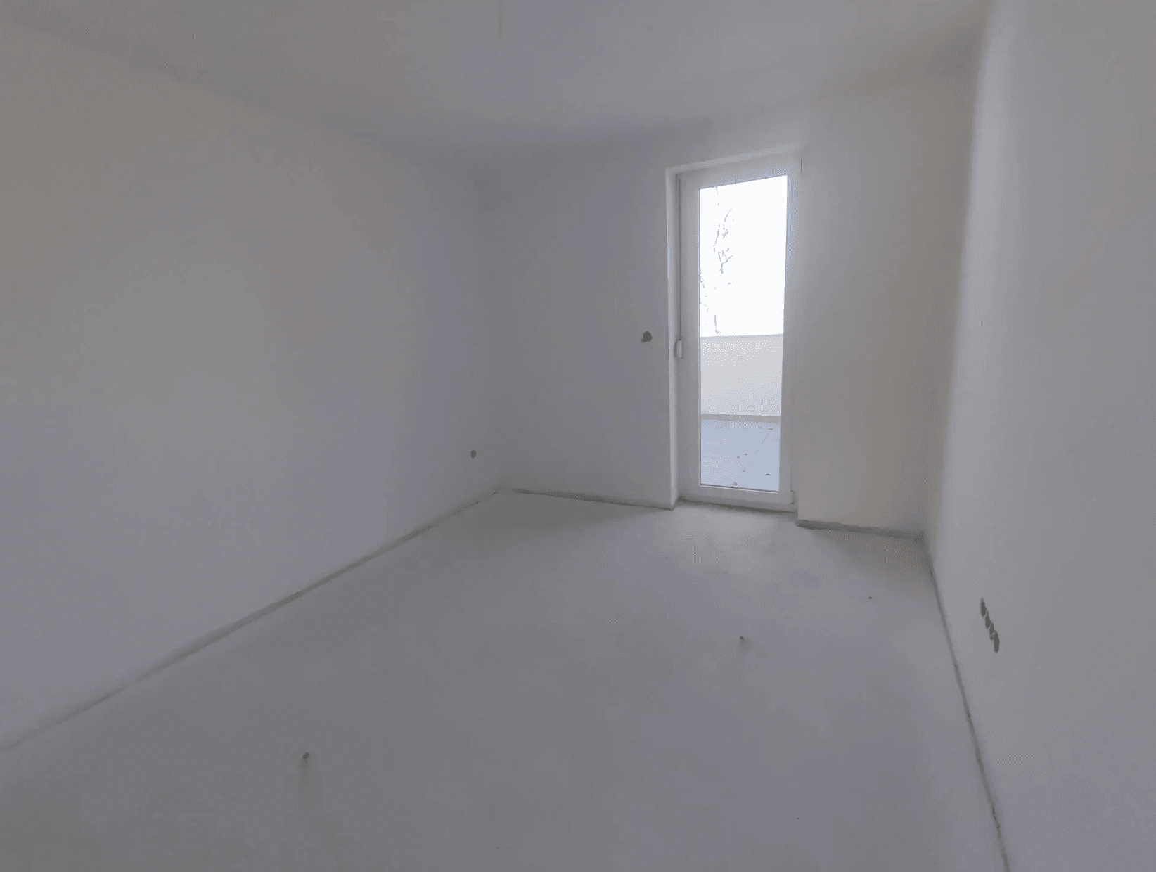 Unfertiges Schlafzimmer mit Rohboden und Zugang zu einem Balkon, bereit für den Ausbau.