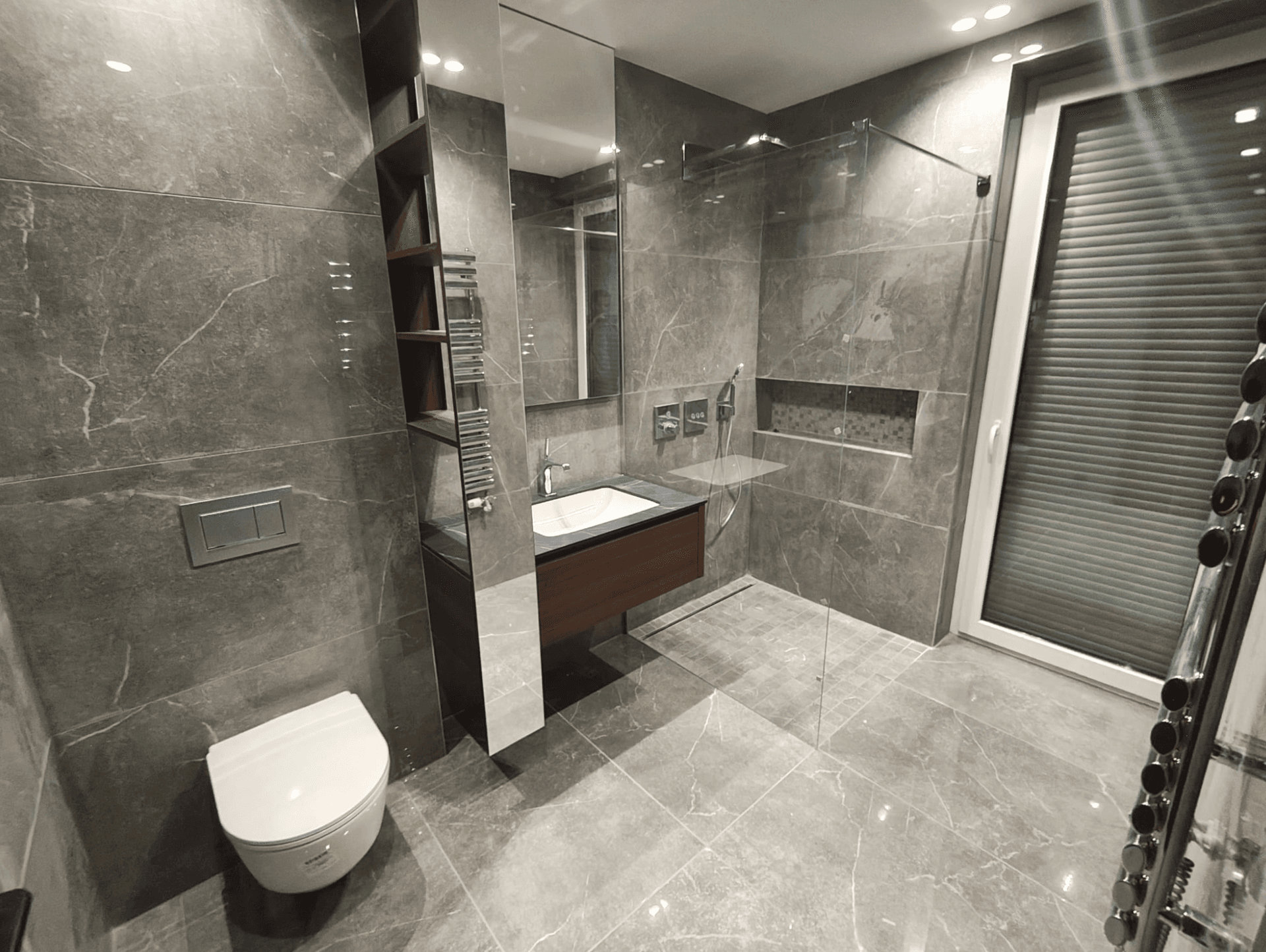Geräumiges Badezimmer mit großer Dusche, wandhängendem WC und Fenster für Tageslicht.