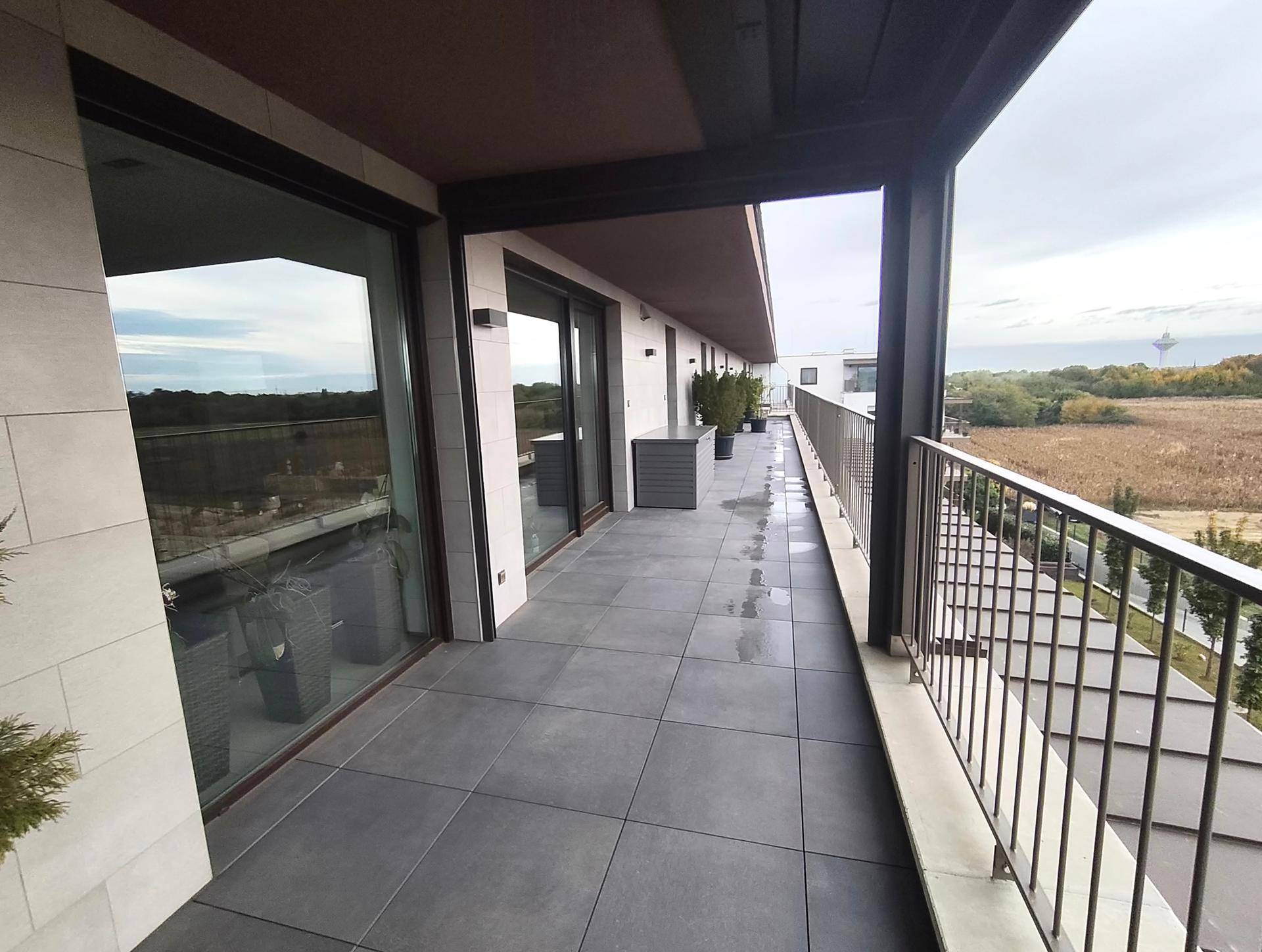 Langer Balkon mit Fliesenboden und Blick auf die Umgebung.