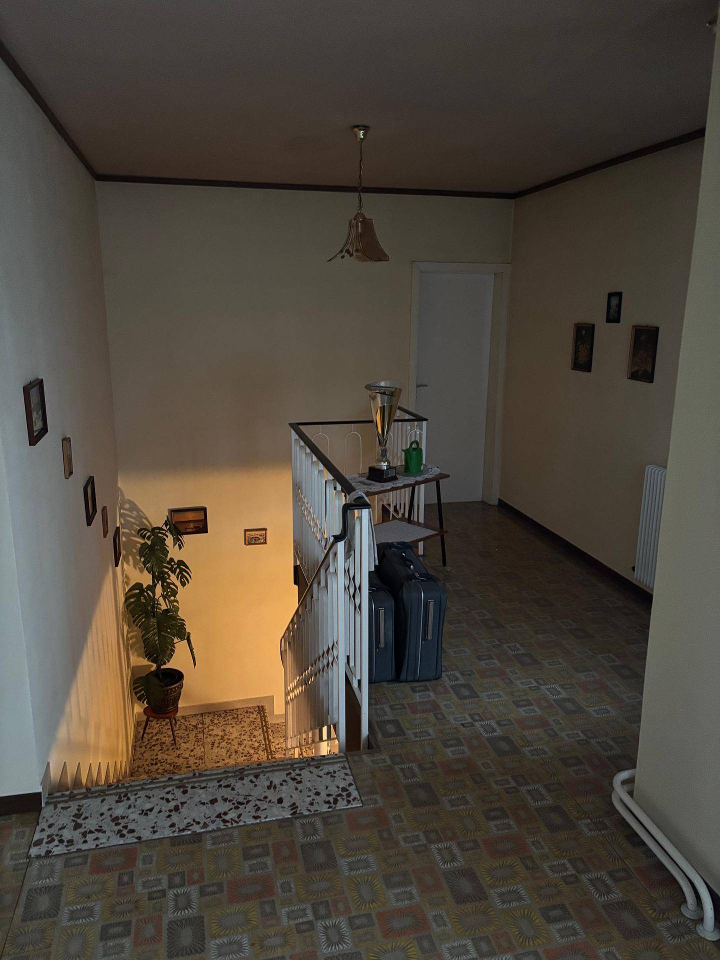 Heller Flur im Obergeschoss mit Treppenabgang, gemustertem Boden und natürlichem Lichteinfall.