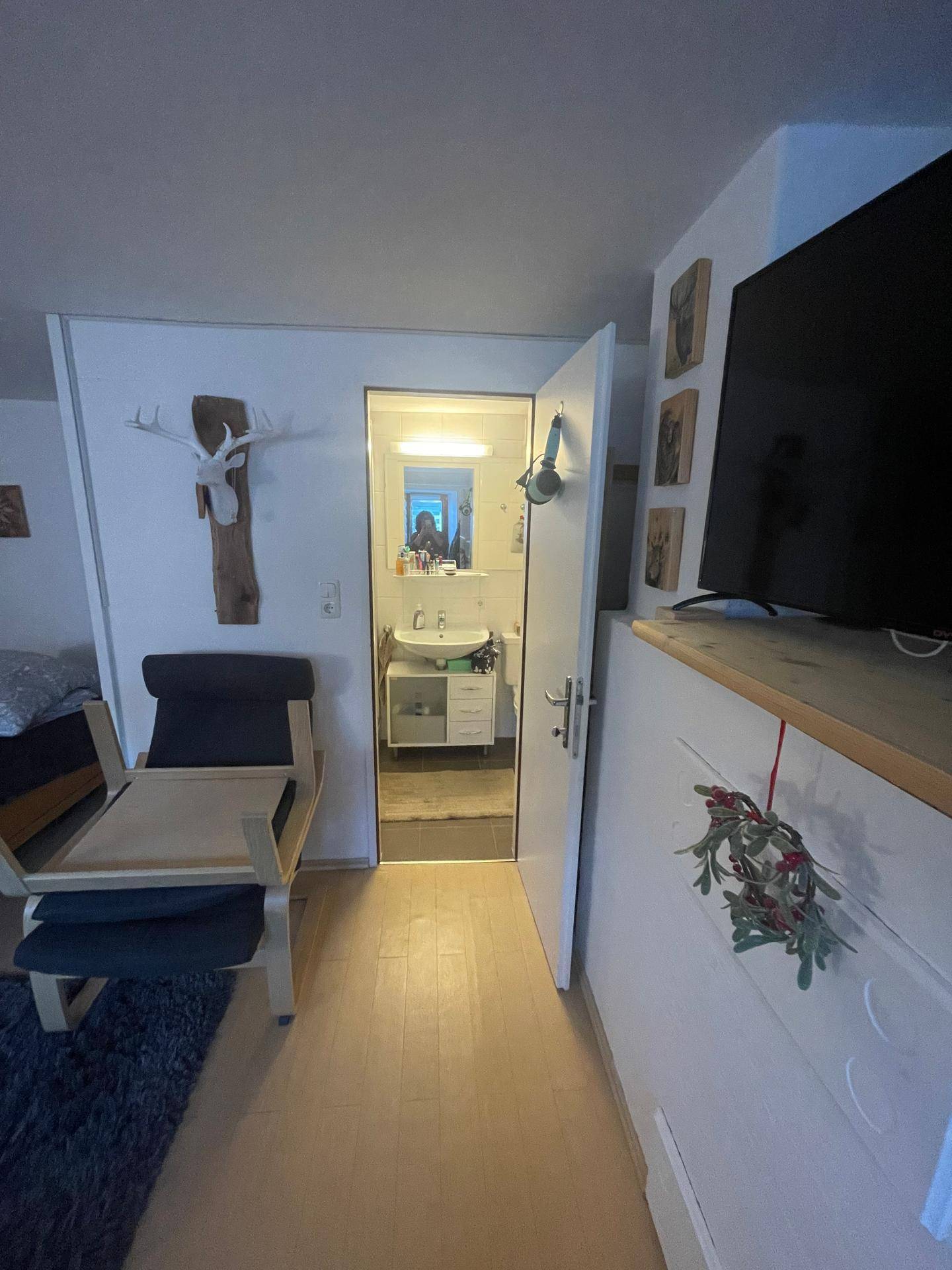 Flur mit Zugang zum Badezimmer, ausgestattet mit einem Hirschgeweih als Dekoration.