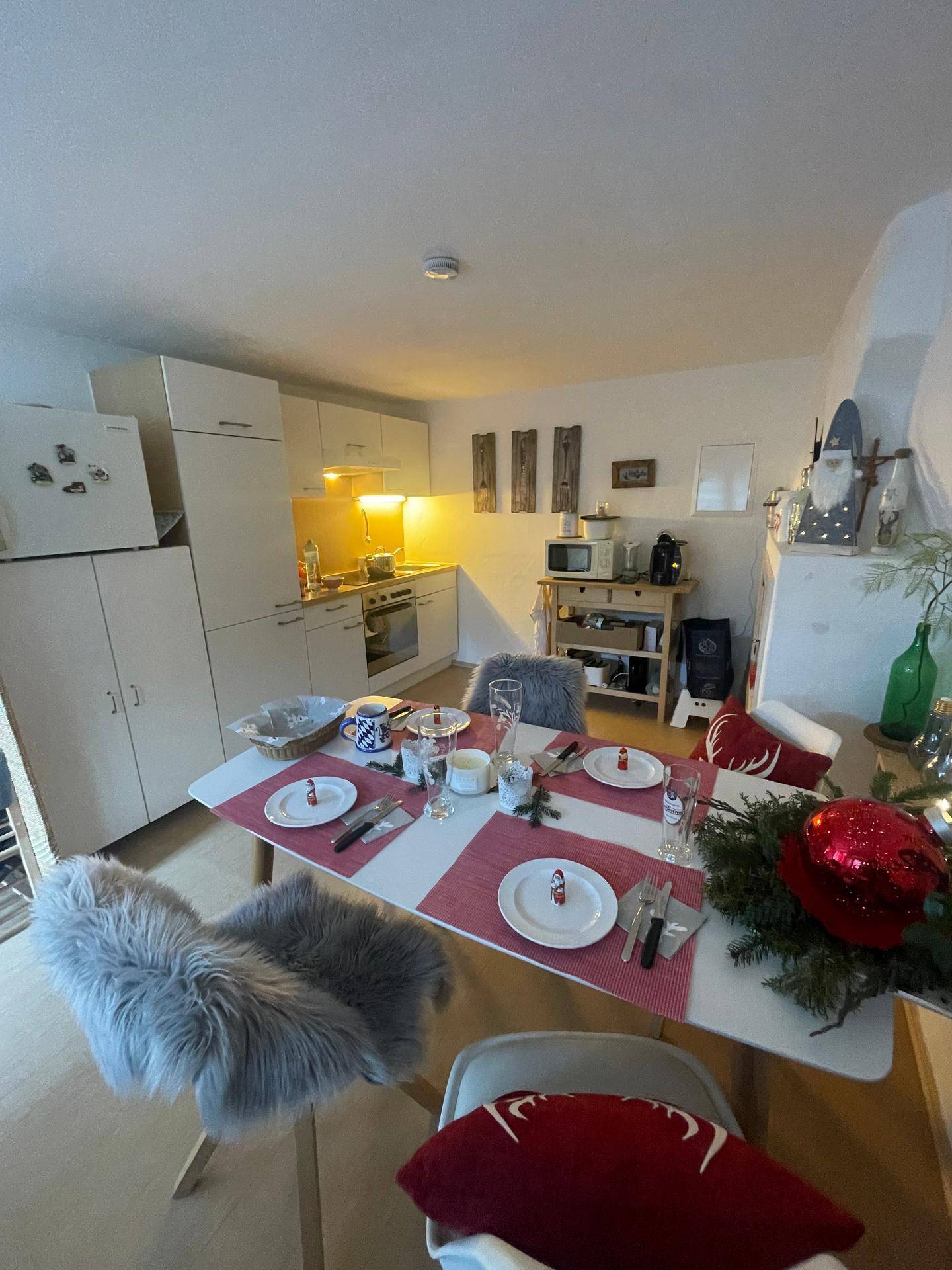 Offener Wohn- und Essbereich mit integrierter Küchenzeile und festlicher Tischdekoration.