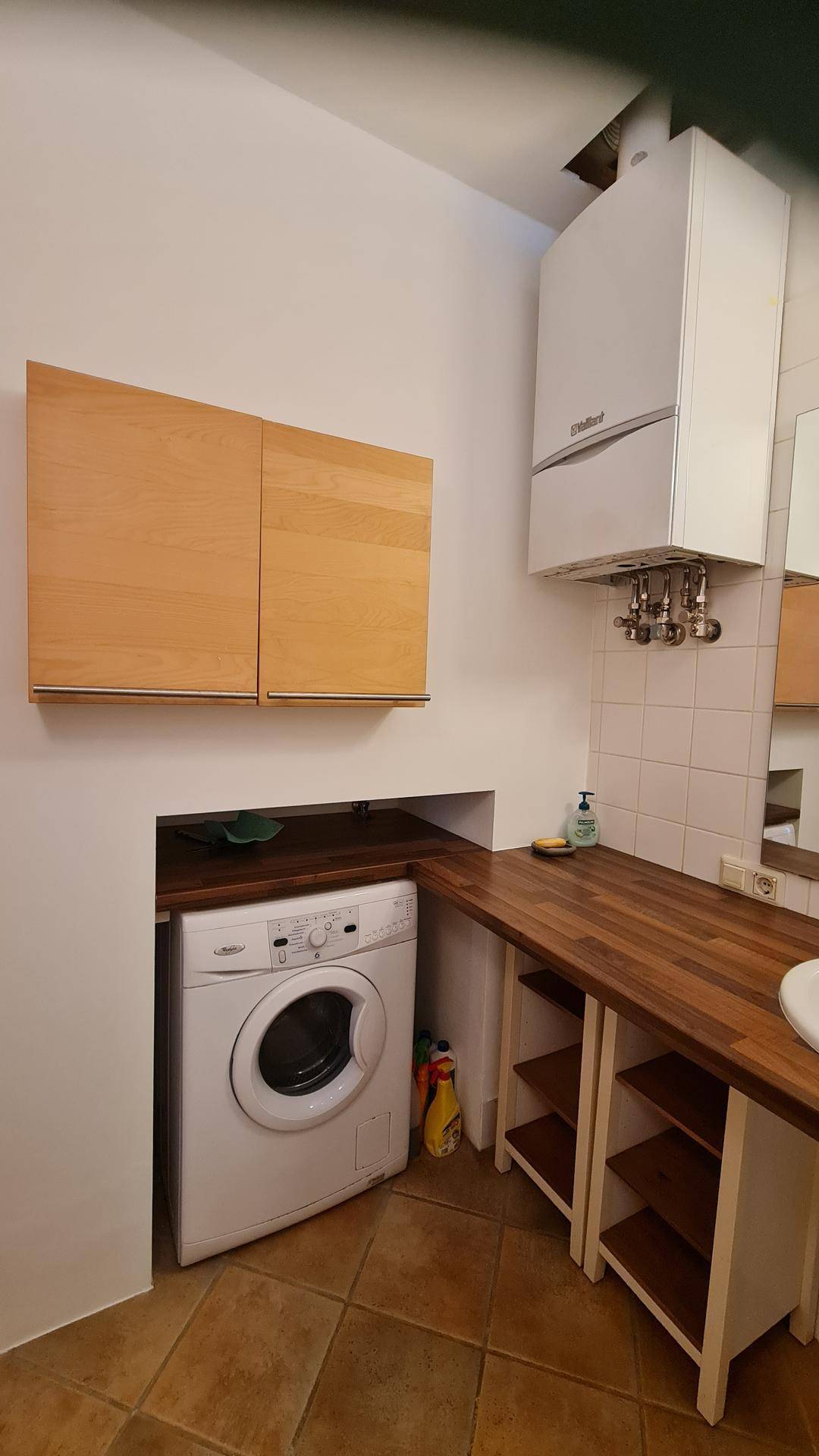 Praktischer Hauswirtschaftsraum mit Waschmaschine, Arbeitsplatte und Gastherme.