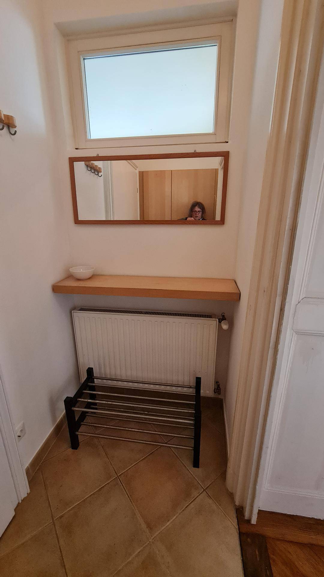 Eingangsbereich mit Spiegel, Schuhregal und Fenster für natürliches Licht.