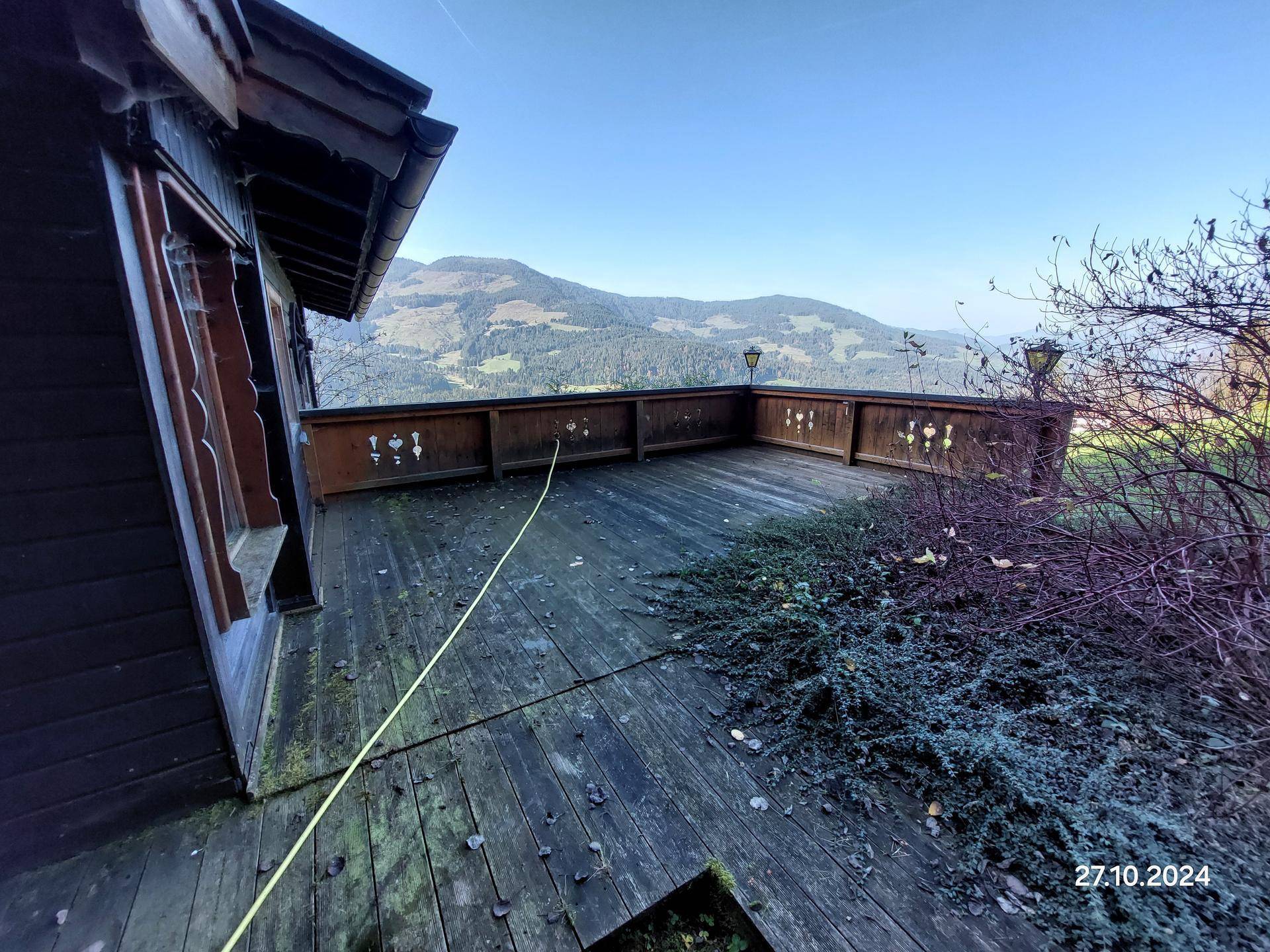 Große Holzterrasse mit weitem Panoramablick auf die umliegende Berglandschaft.