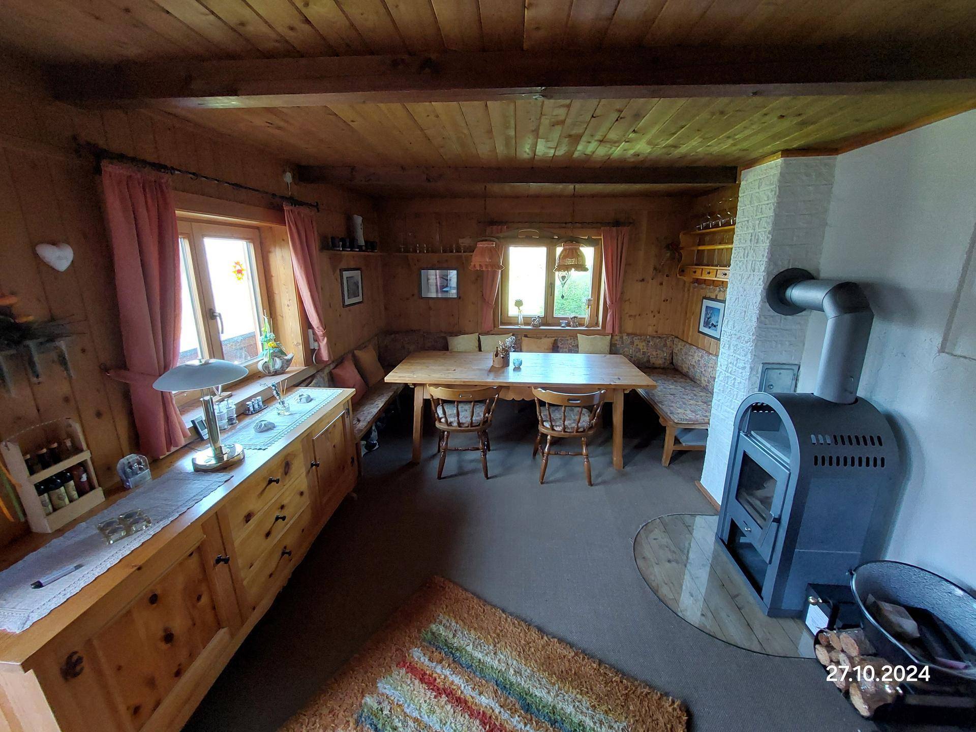 Rustikaler Essbereich mit Holztisch, Eckbank und einem gemütlichen Holzofen.