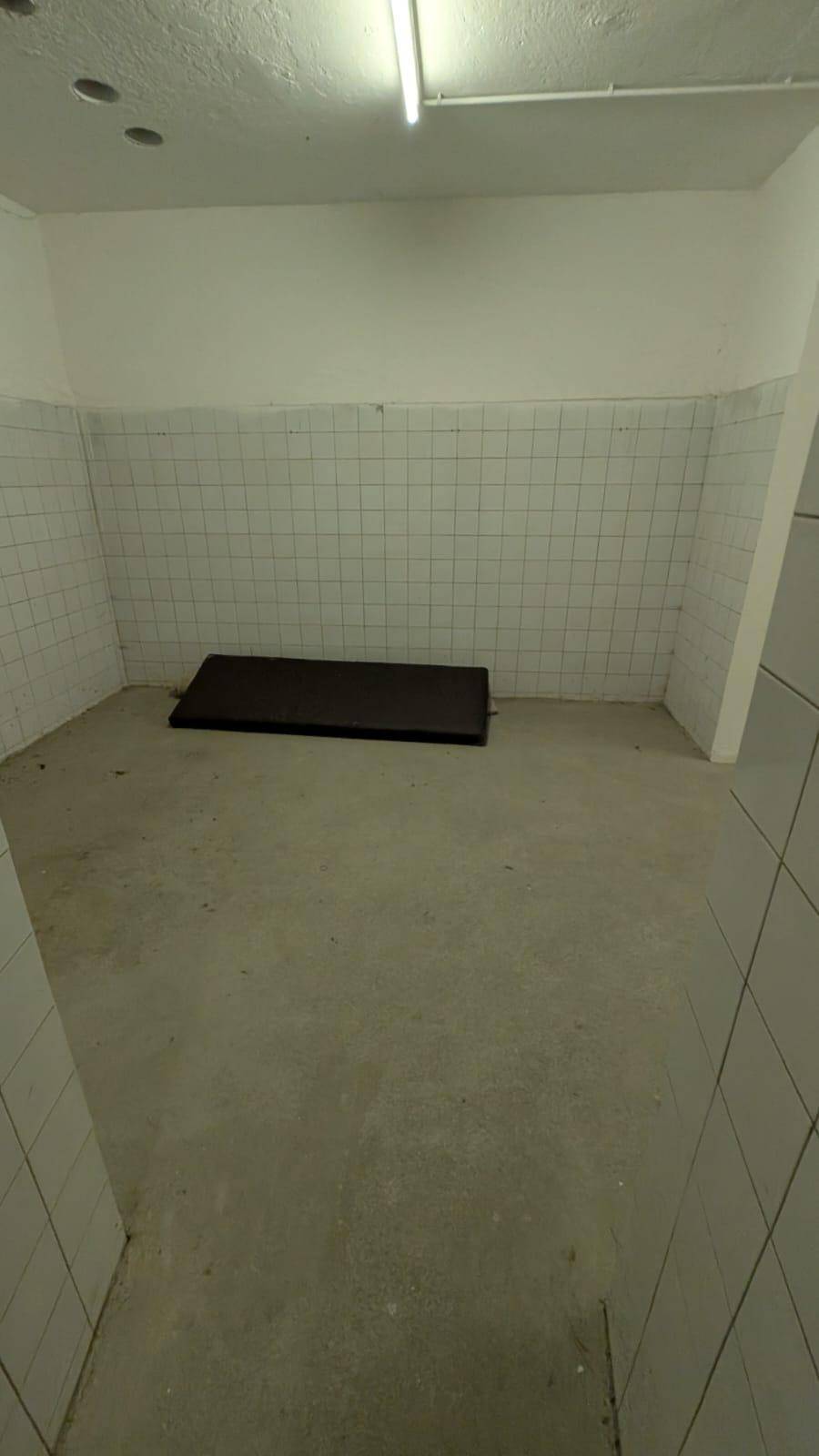 Funktionaler Kellerraum mit gefliesten Wänden und Betonboden, geeignet für diverse Zwecke.