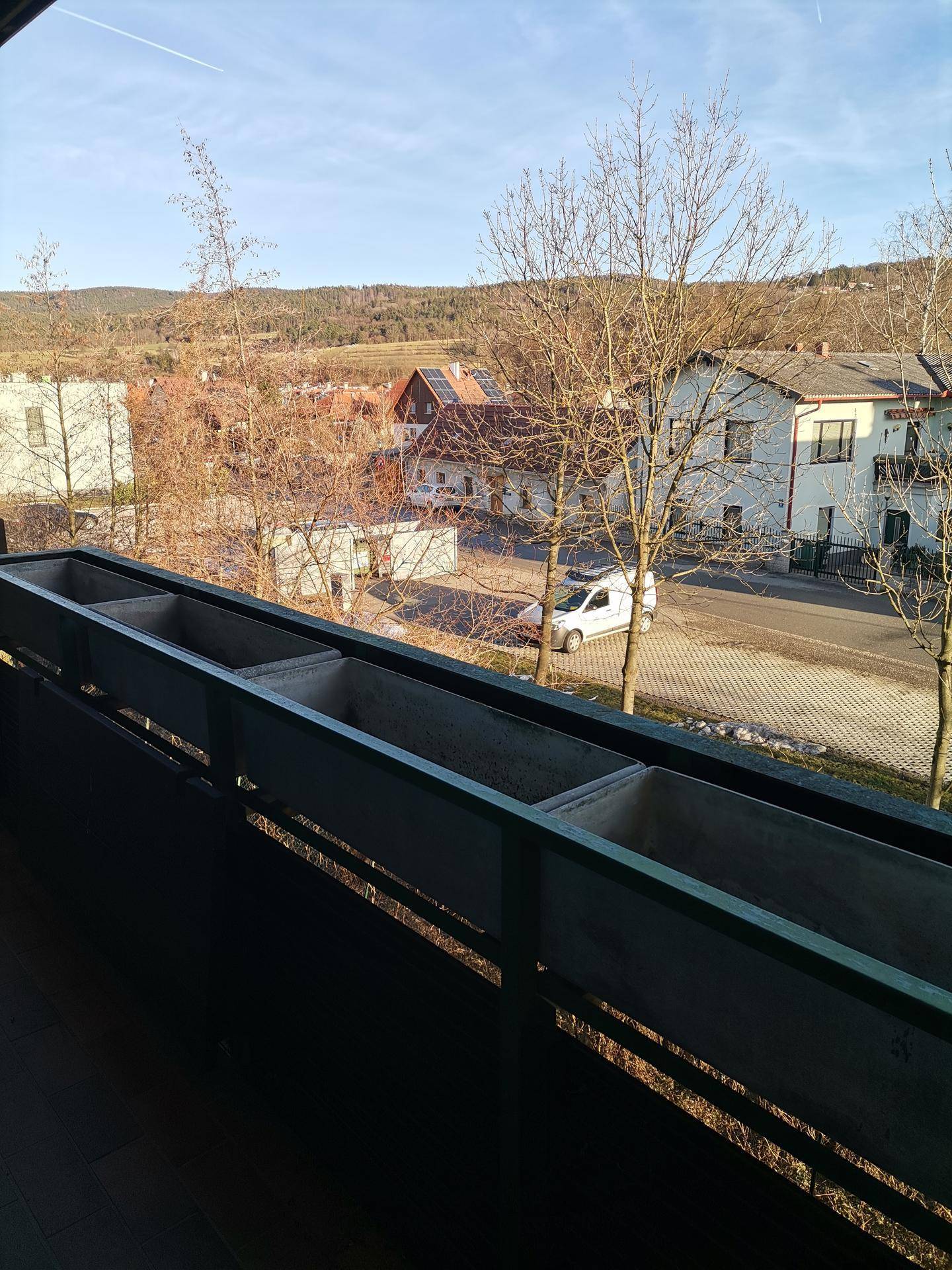 Balkon mit Blumenkästen und weitem Blick über die ländliche Umgebung.