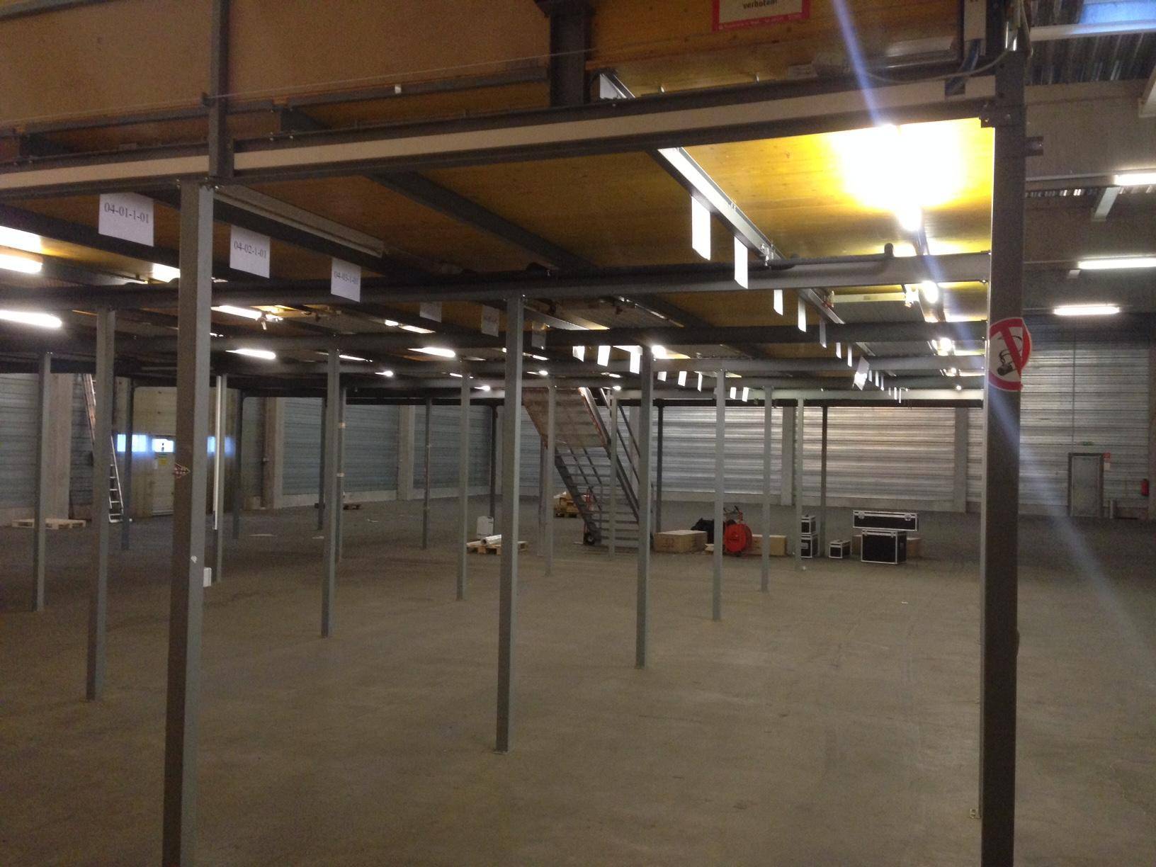 Lagerhalle mit Zwischengeschoss-Konstruktion aus Metall und Holz, bereit zur Einrichtung.