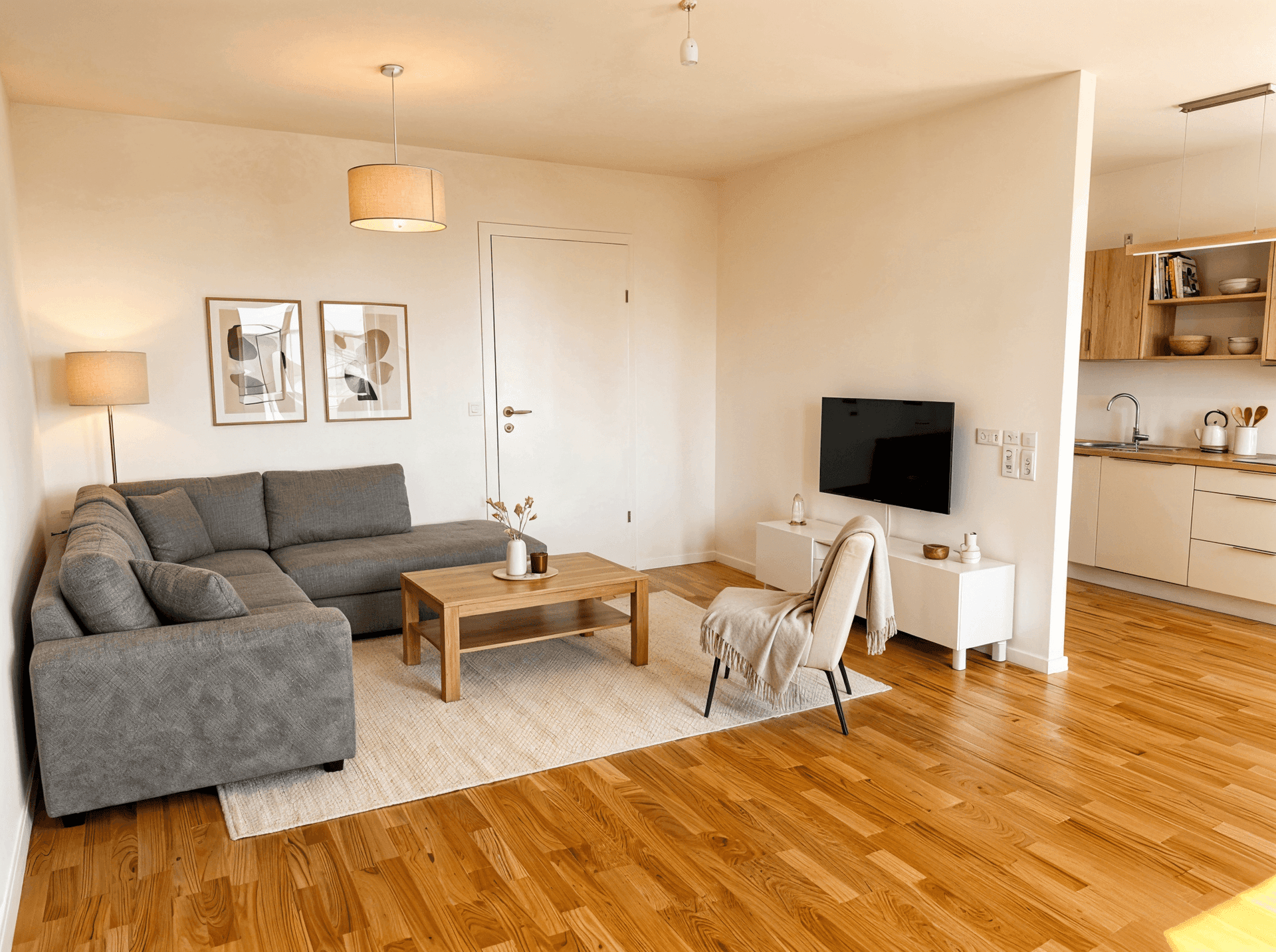 Gemütlicher Wohnbereich mit Ecksofa, Holzboden und offener Verbindung zur Küche.