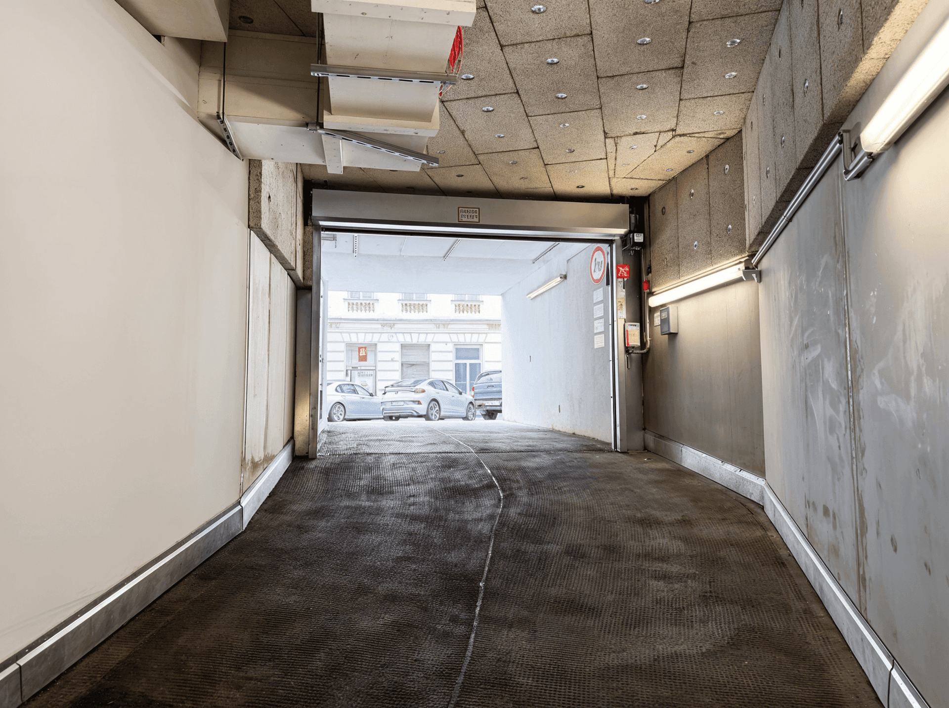 Ausfahrt einer Tiefgarage mit Blick auf die Straße und weitere Fahrzeuge.
