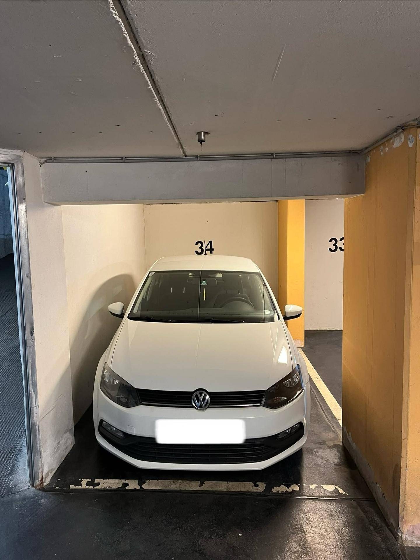 Weißes Fahrzeug auf einem nummerierten Stellplatz in der Tiefgarage.