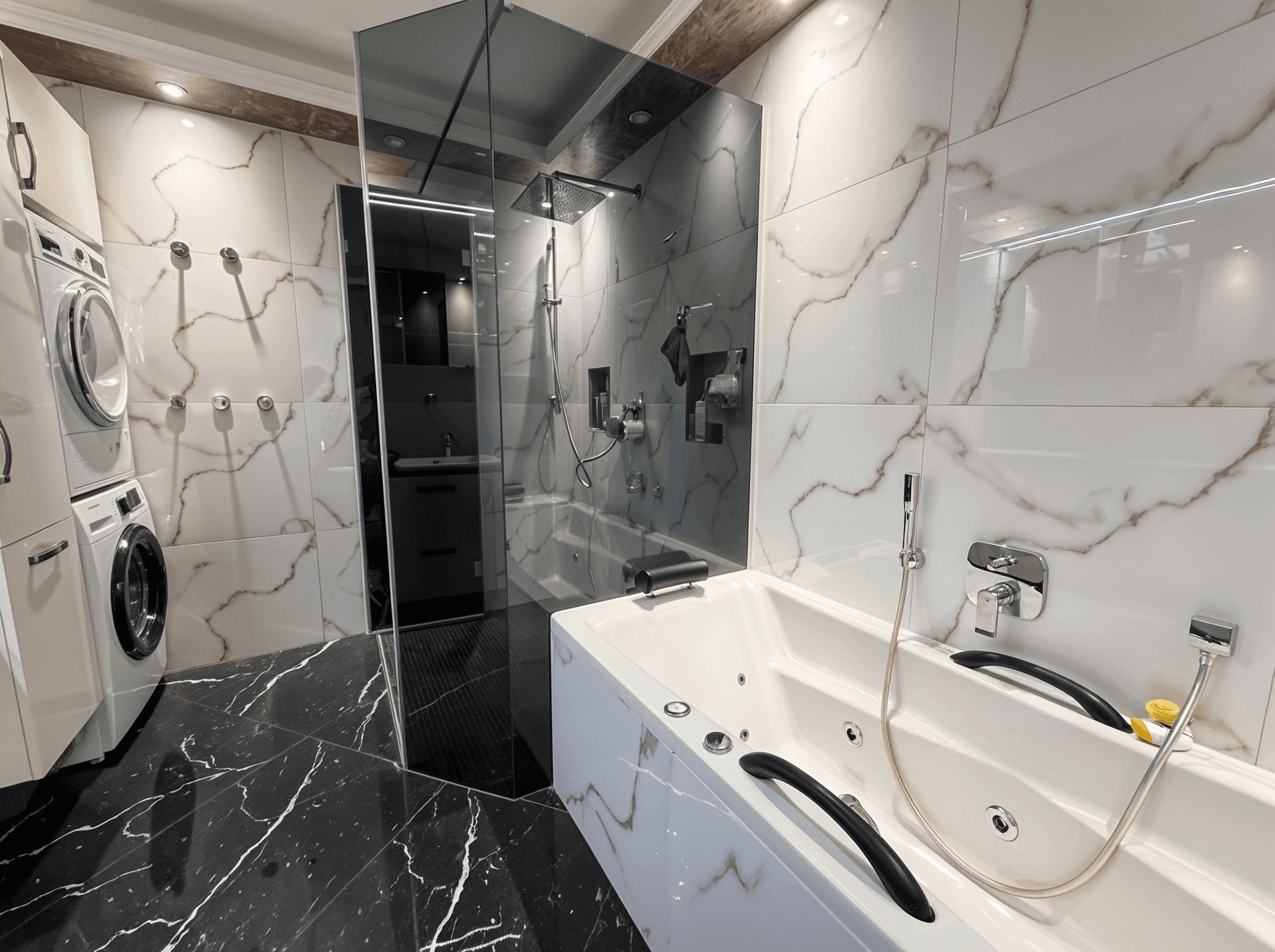 Modernes Badezimmer mit Whirlpool-Badewanne, begehbarer Dusche und Waschmaschine.