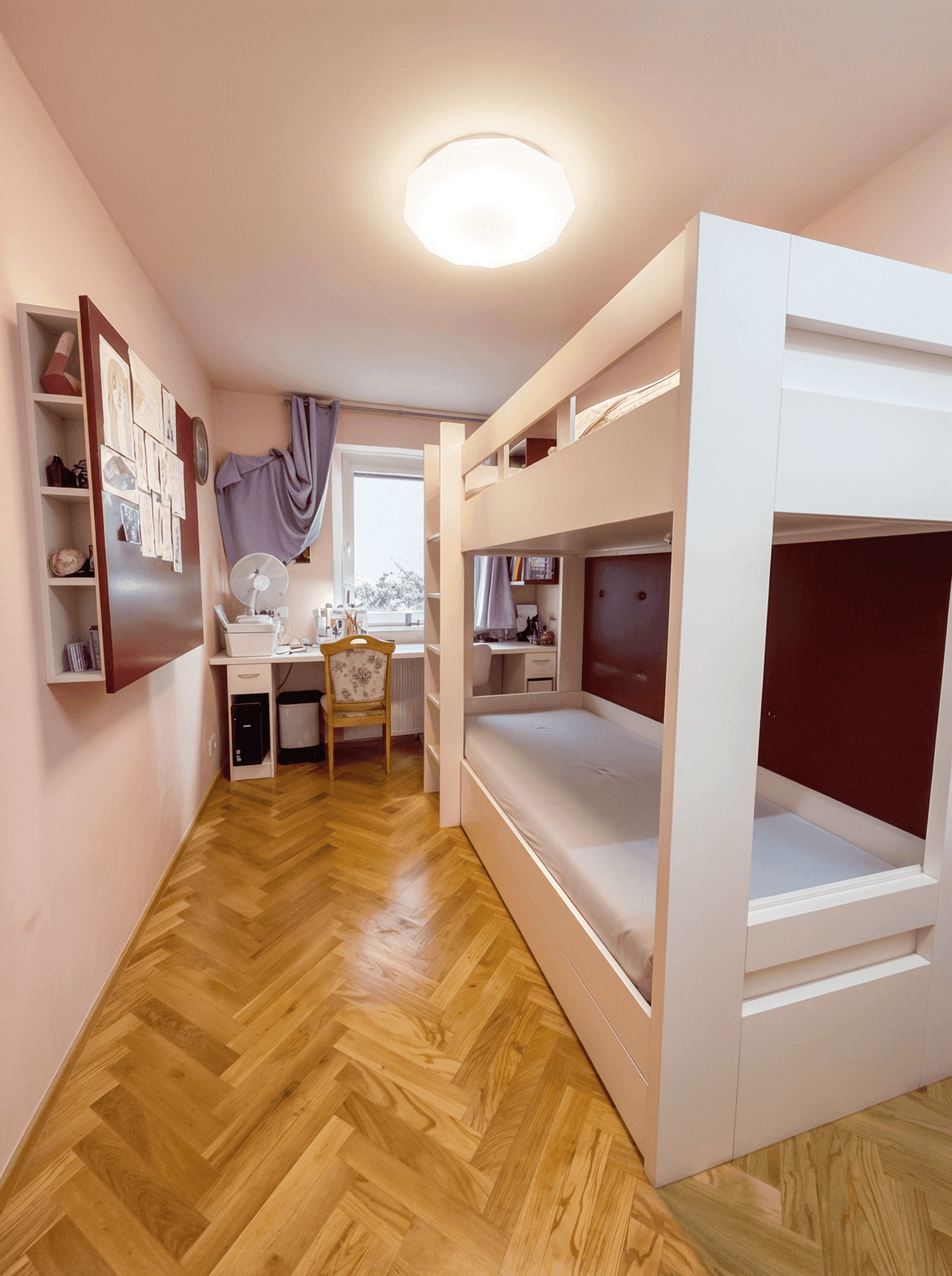 Kinderzimmer mit Etagenbett, Schreibtisch und Parkettboden.