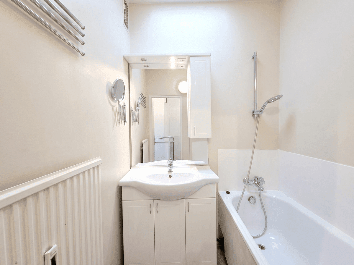 Leeres Badezimmer mit Badewanne, Waschbecken und Spiegel.
