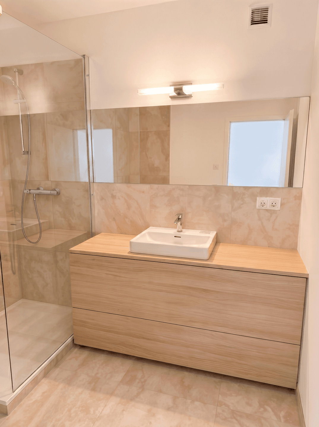Modernes Badezimmer mit begehbarer Dusche, Holzwaschtisch und beigefarbenen Fliesen.