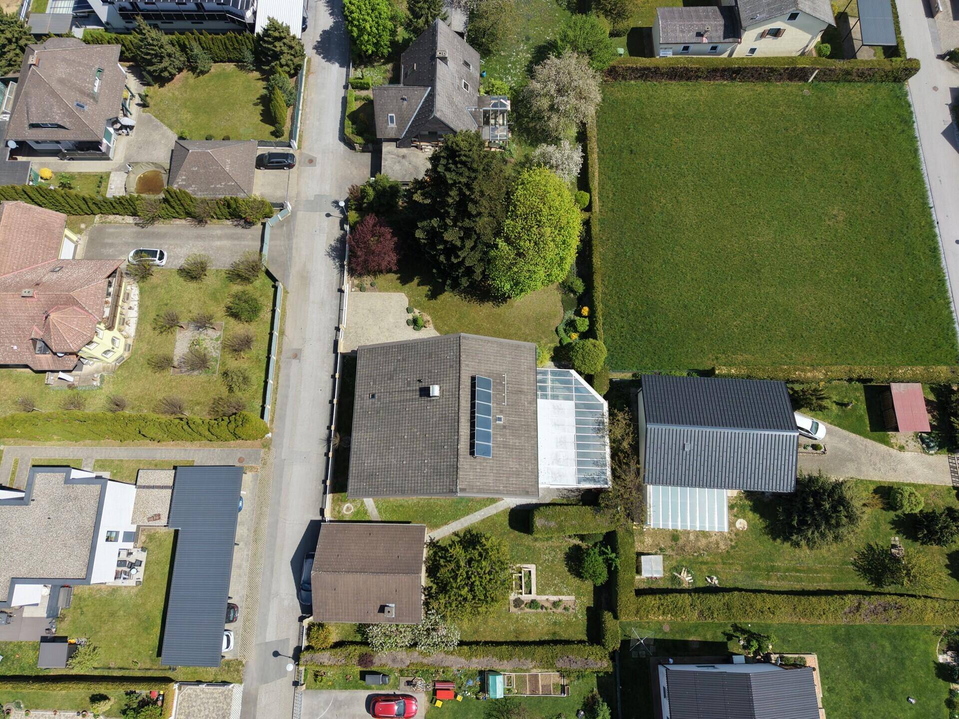 Draufsicht auf das Grundstück mit Haus, Garten und angrenzenden Feldern.