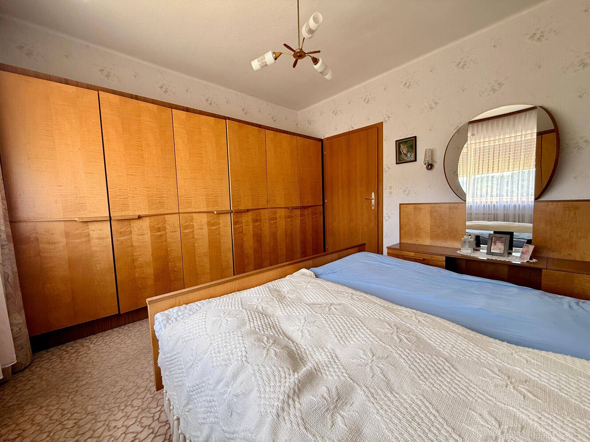 Schlafzimmer mit Einbauschränken aus Holz und einem Doppelbett, im klassischen Stil eingerichtet.