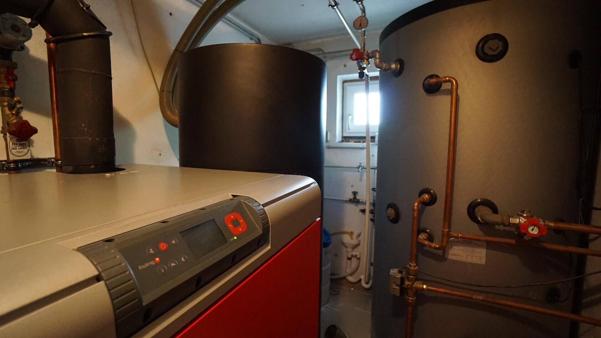 Funktionaler Heizungsraum mit modernen Heizkesseln und Warmwasserspeichern, gut organisiert und gepflegt.