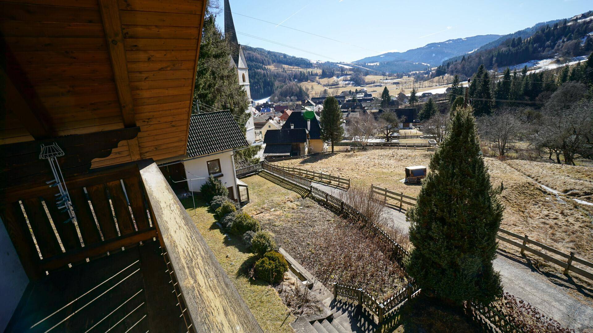 Balkon mit weitem Blick auf die Kirche, das Tal und die umliegende Berglandschaft.
