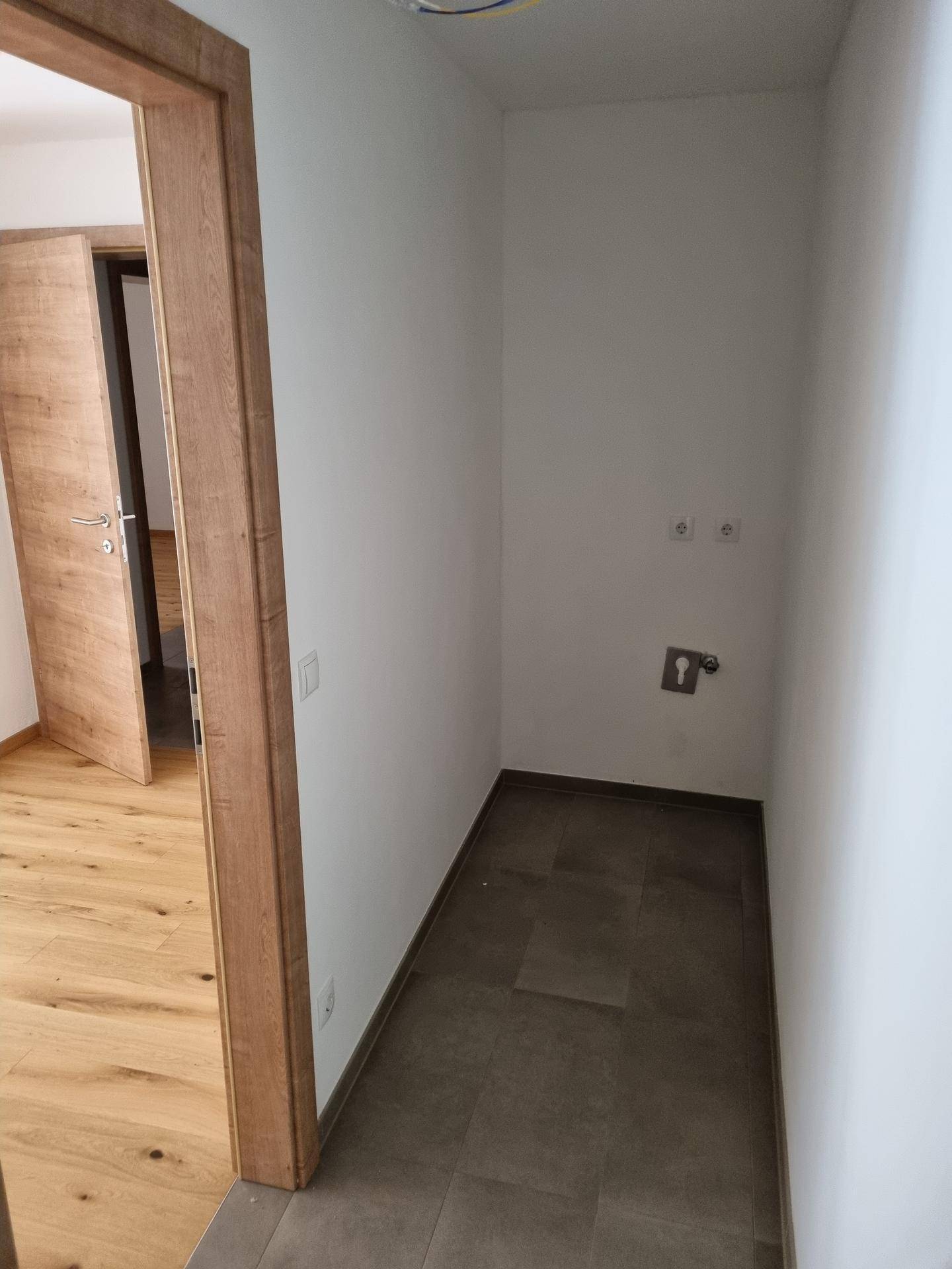 Praktischer Hauswirtschaftsraum mit Fliesenboden und Anschlüssen für Waschmaschine und Trockner.