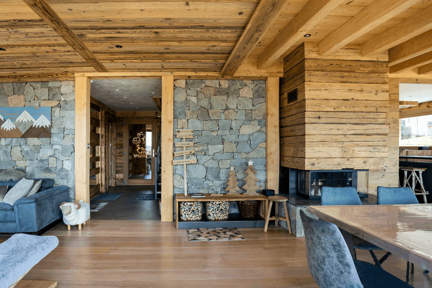 Geräumiger Wohnbereich mit Steinwand, Holzboden und einem modernen Kamin als Mittelpunkt.