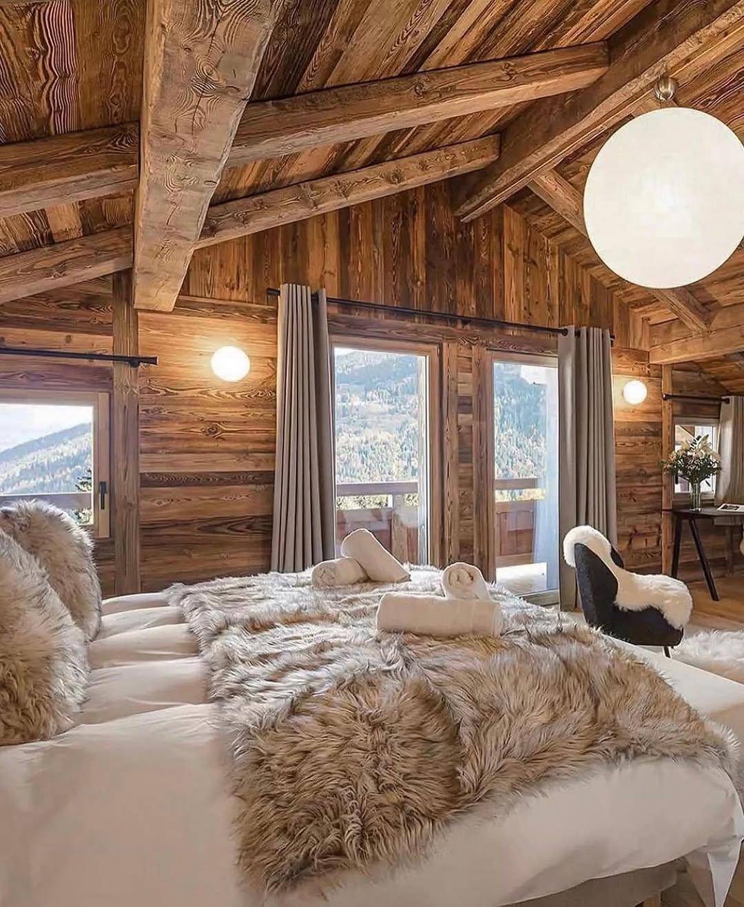 Luxuriöses Schlafzimmer mit Holzwänden, großem Bett und Bergblick, bietet höchsten Komfort.