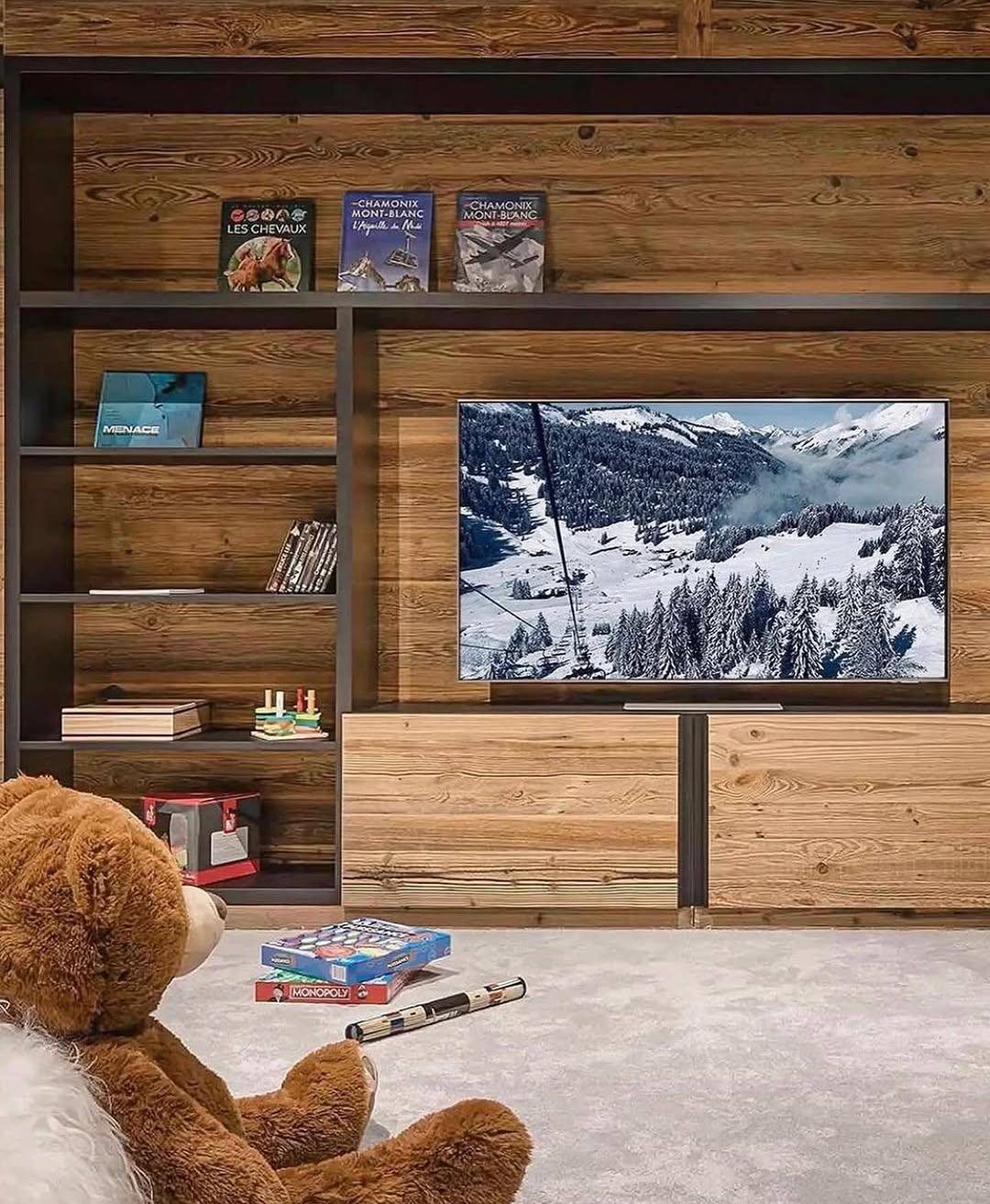 Unterhaltungsbereich mit großem Fernseher und Holzregalen, ideal für gemütliche Filmabende.