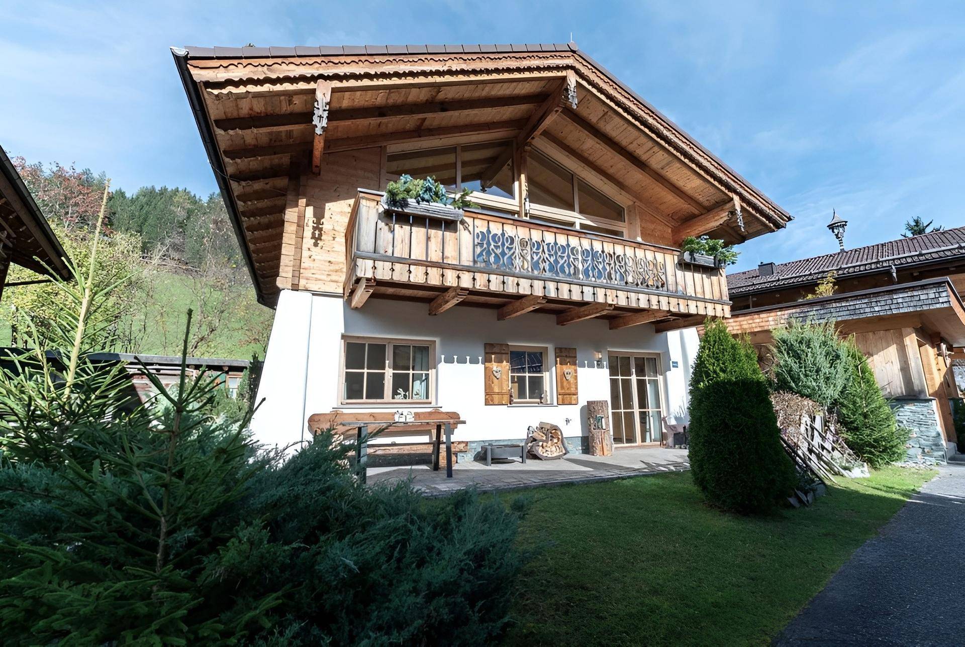 Charmantes Chalet mit Holzbalkonen, Satteldach und gepflegtem Vorgarten in alpiner Umgebung.