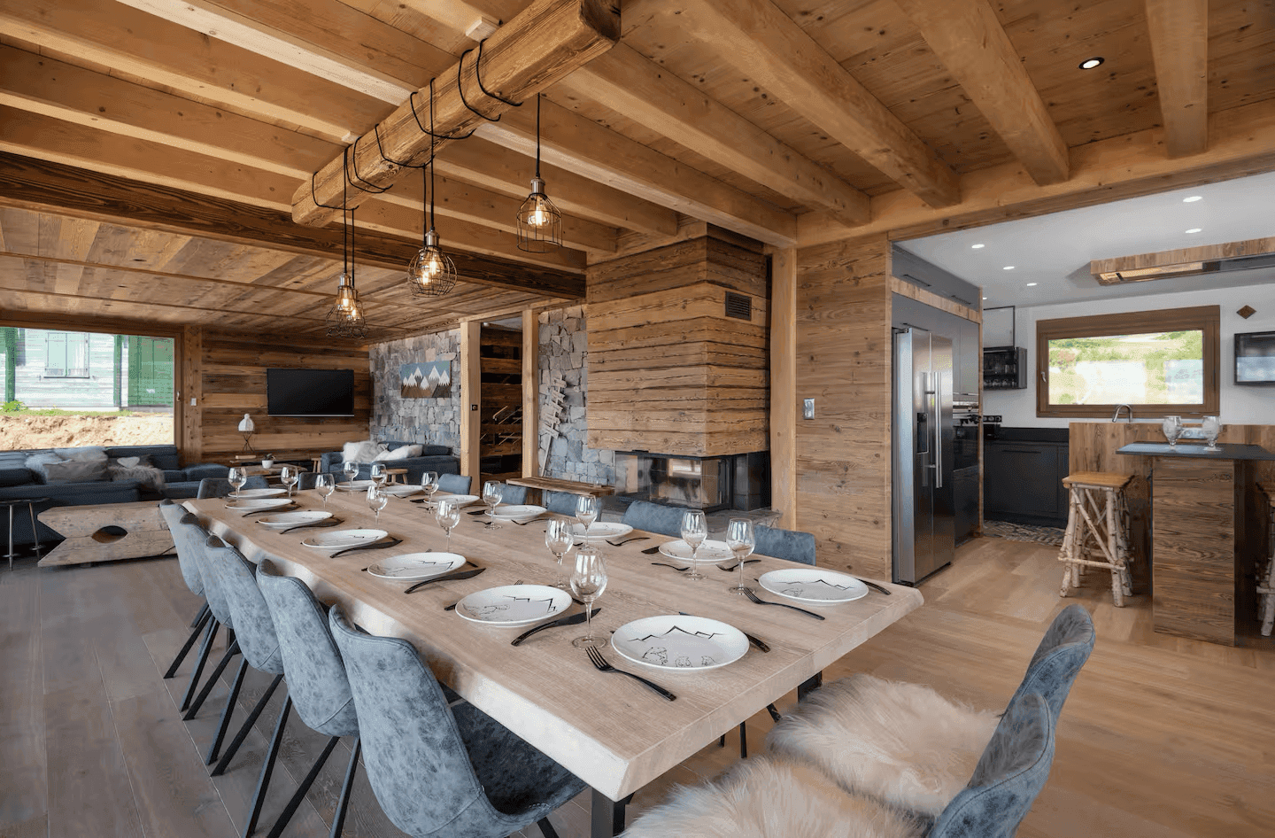 Geräumiger Wohn-Essbereich mit Holzbalkendecke, großem Esstisch und integriertem Kamin.