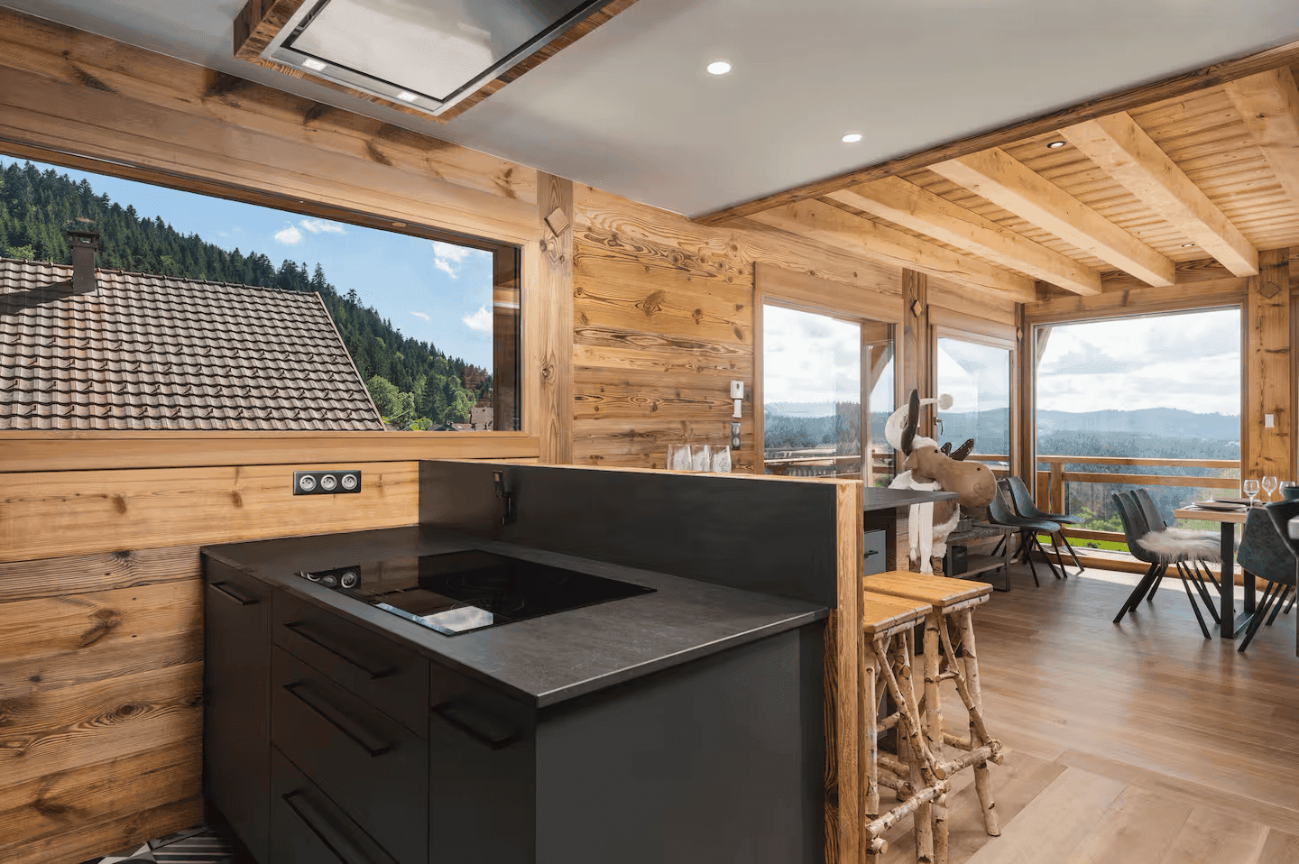 Moderne Küche mit dunklen Arbeitsplatten und einem Fenster, das einen weiten Blick in die Natur bietet.