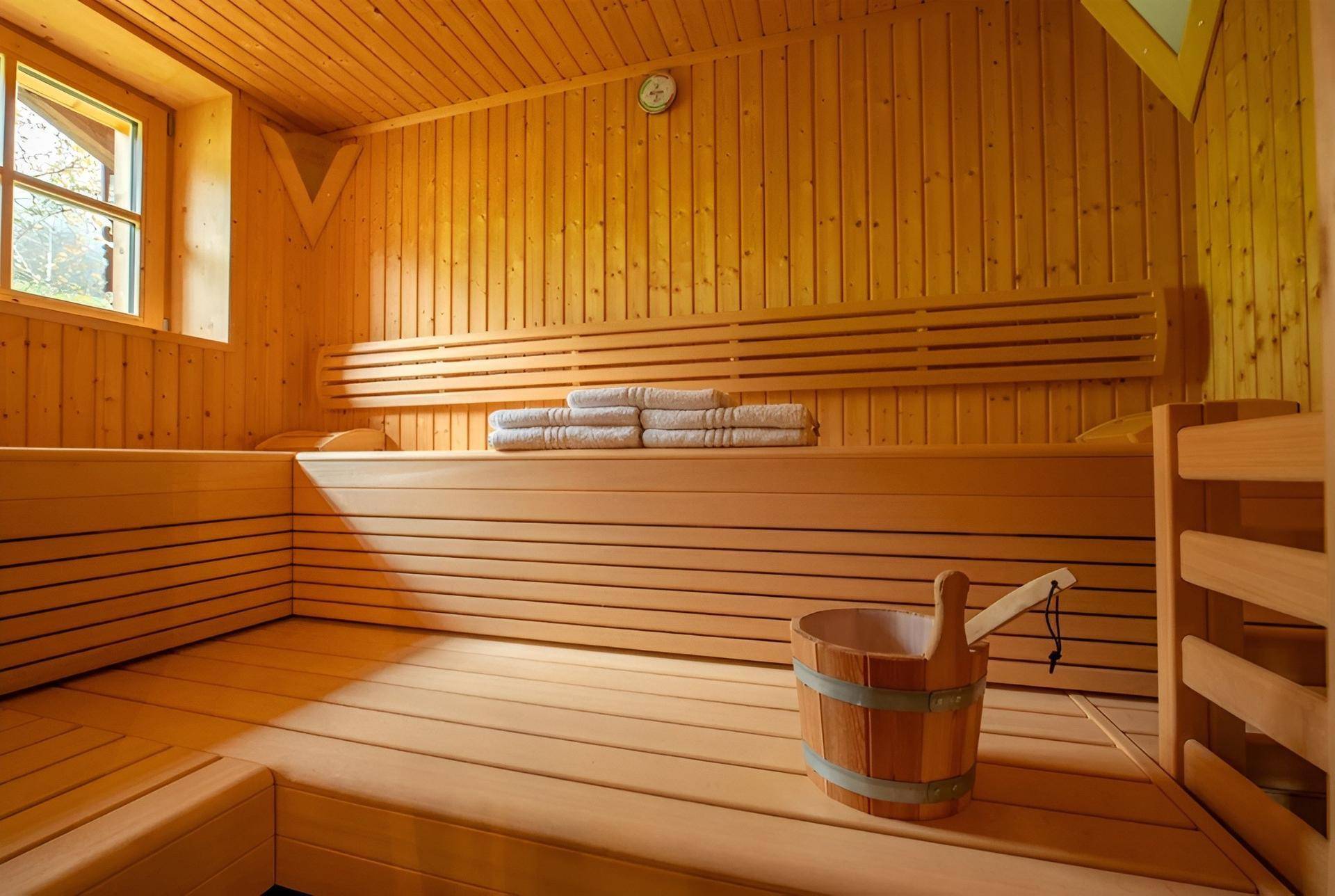 Traditionelle Holzsauna mit Bänken und einem Fenster für natürliche Belüftung.