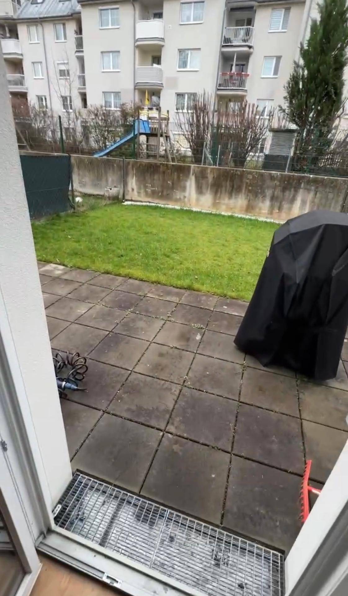 Private Terrasse mit Gartenbereich, Rasenfläche und Blick auf einen Kinderspielplatz.