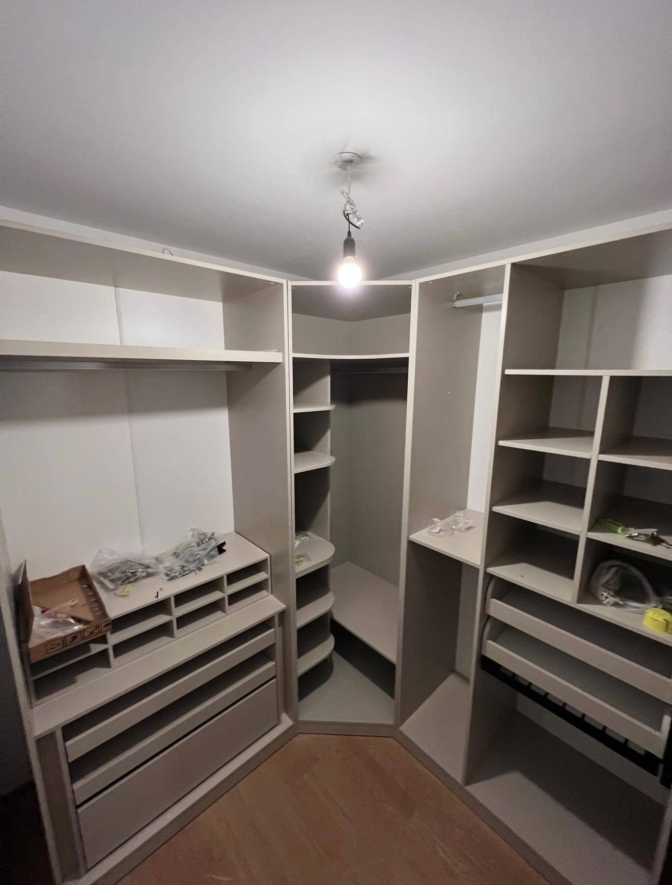 Geräumiger begehbarer Kleiderschrank mit offenen Regalen und Schubladen für viel Stauraum.